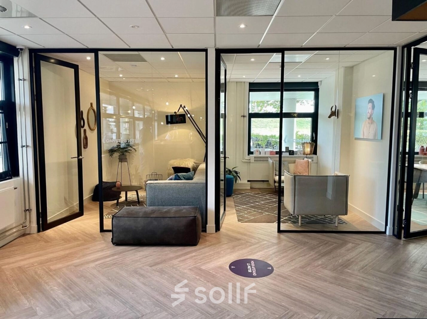 Modern office space with glass-walled meeting rooms at Johan de Wittlaan, The Hague. Ideal for office space rental with stylish furniture and natural lighting.