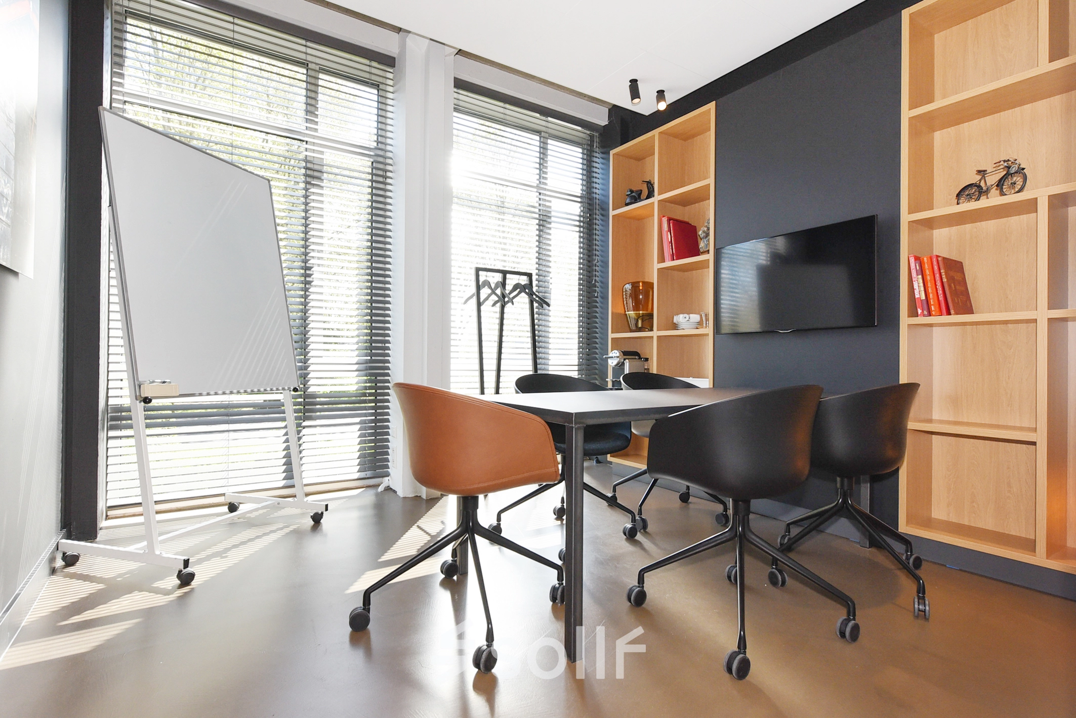 Bright office to rent at President Kennedylaan 19, The Hague Statenkwartier, featuring modern furnishings, a large window for natural light, and a sleek table with chairs ideal for meetings.