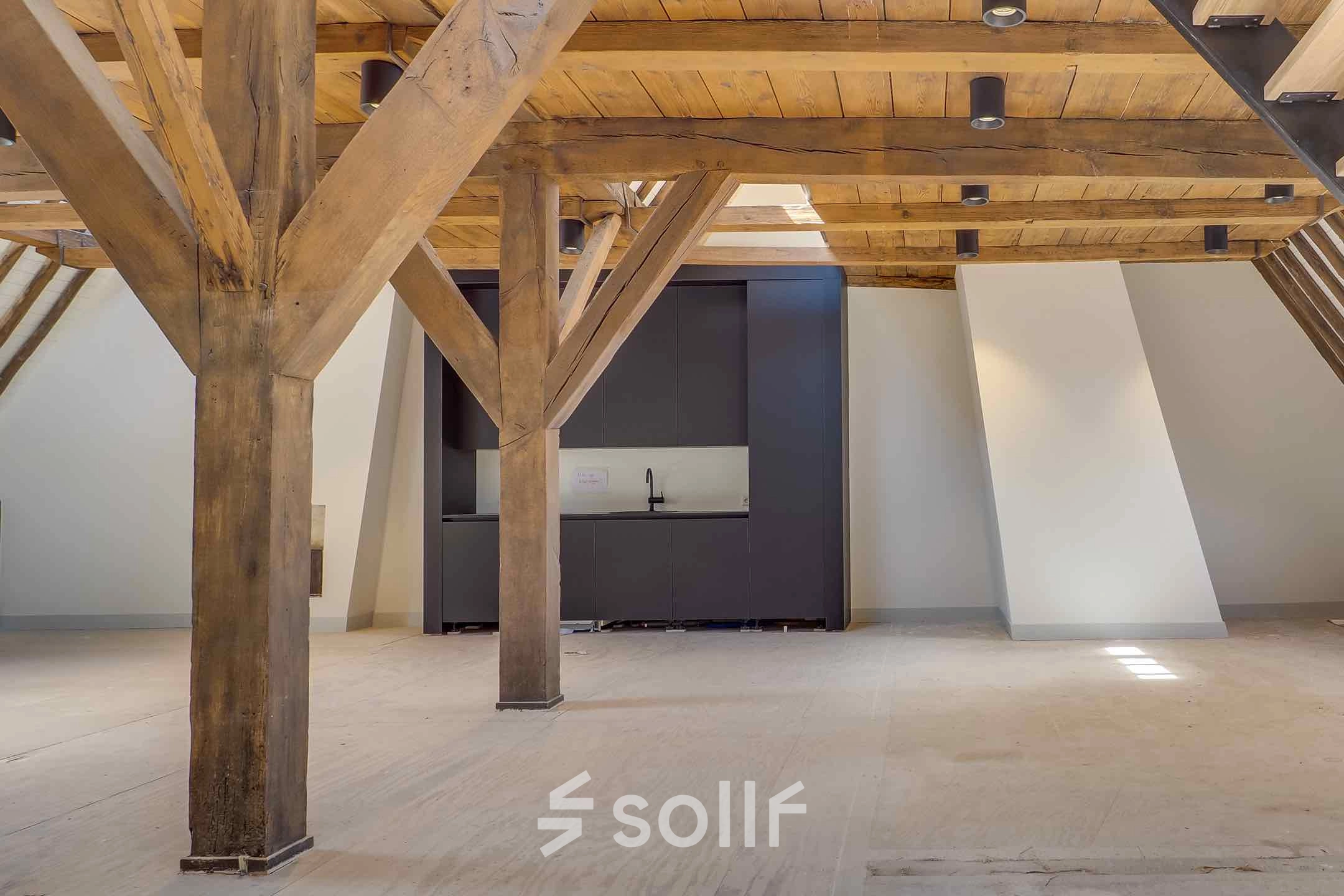 Spacious office space with rustic wooden beams and a small kitchenette area at Brigittenstraat 22, ideal for office space rental in Utrecht Center.