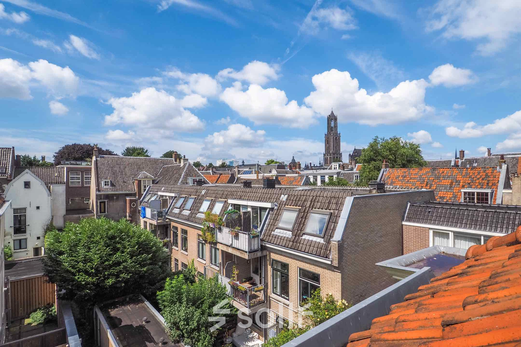 A picturesque view of buildings and rooftops in Utrecht Center, showcasing potential office to rent. The iconic tower provides a scenic backdrop for this office space rental option.