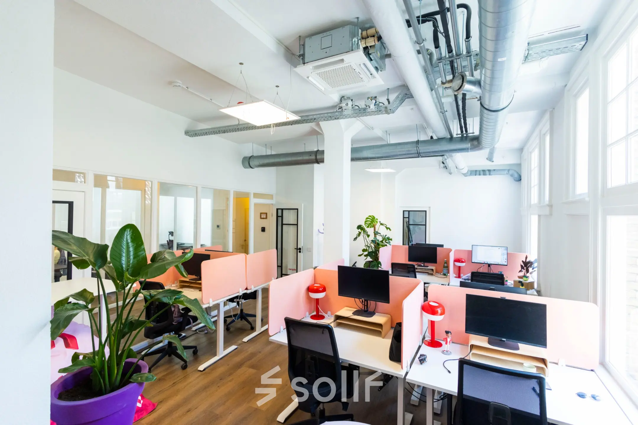 Bright office space with multiple workstations at Oudegracht 161, Utrecht Center, available for rent. The furnished interior includes large windows and modern decor, ideal for office space rental.