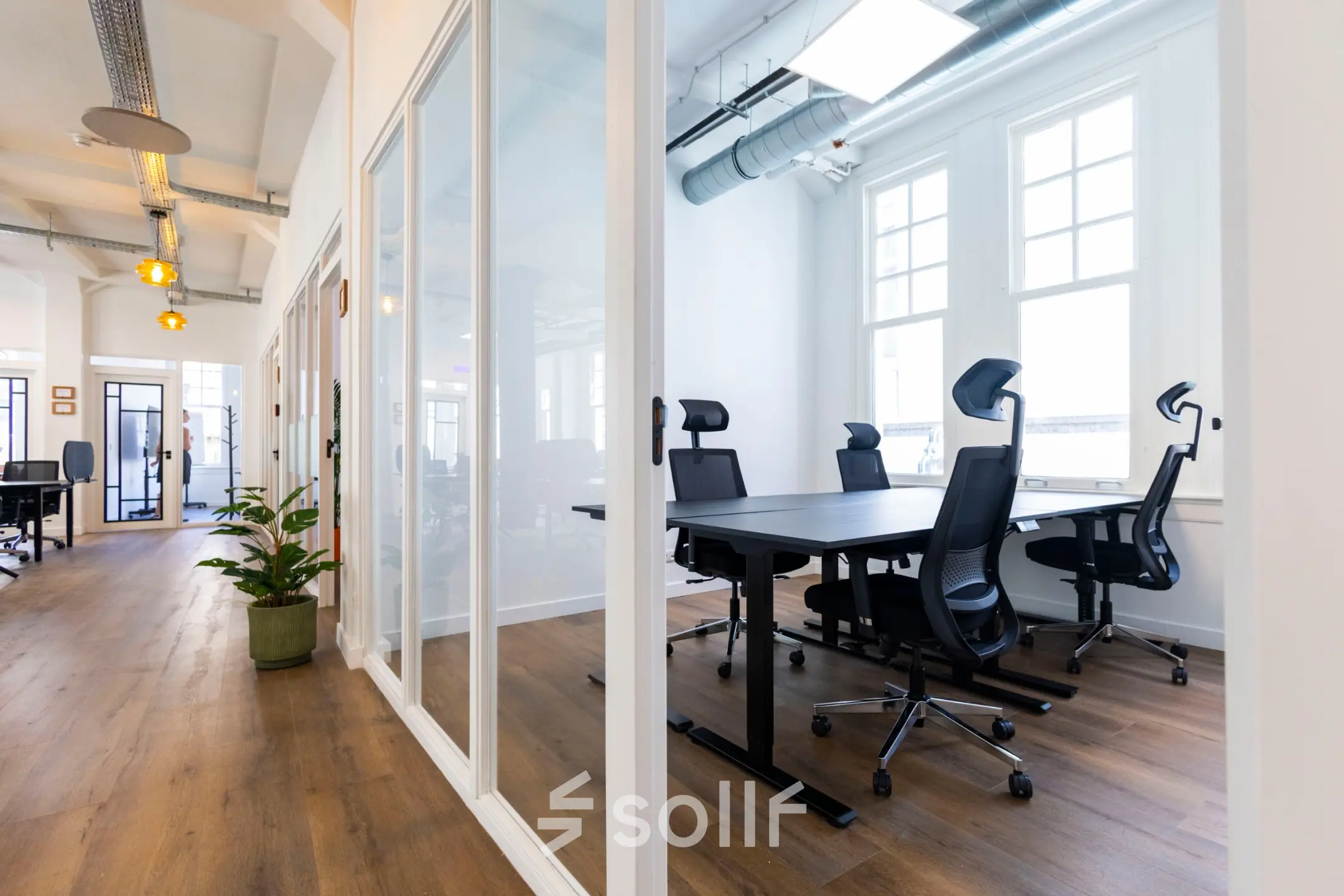 Bright office space with sleek furnishings and large windows at Oudegracht 161, Utrecht Center, ideal for office space rental.