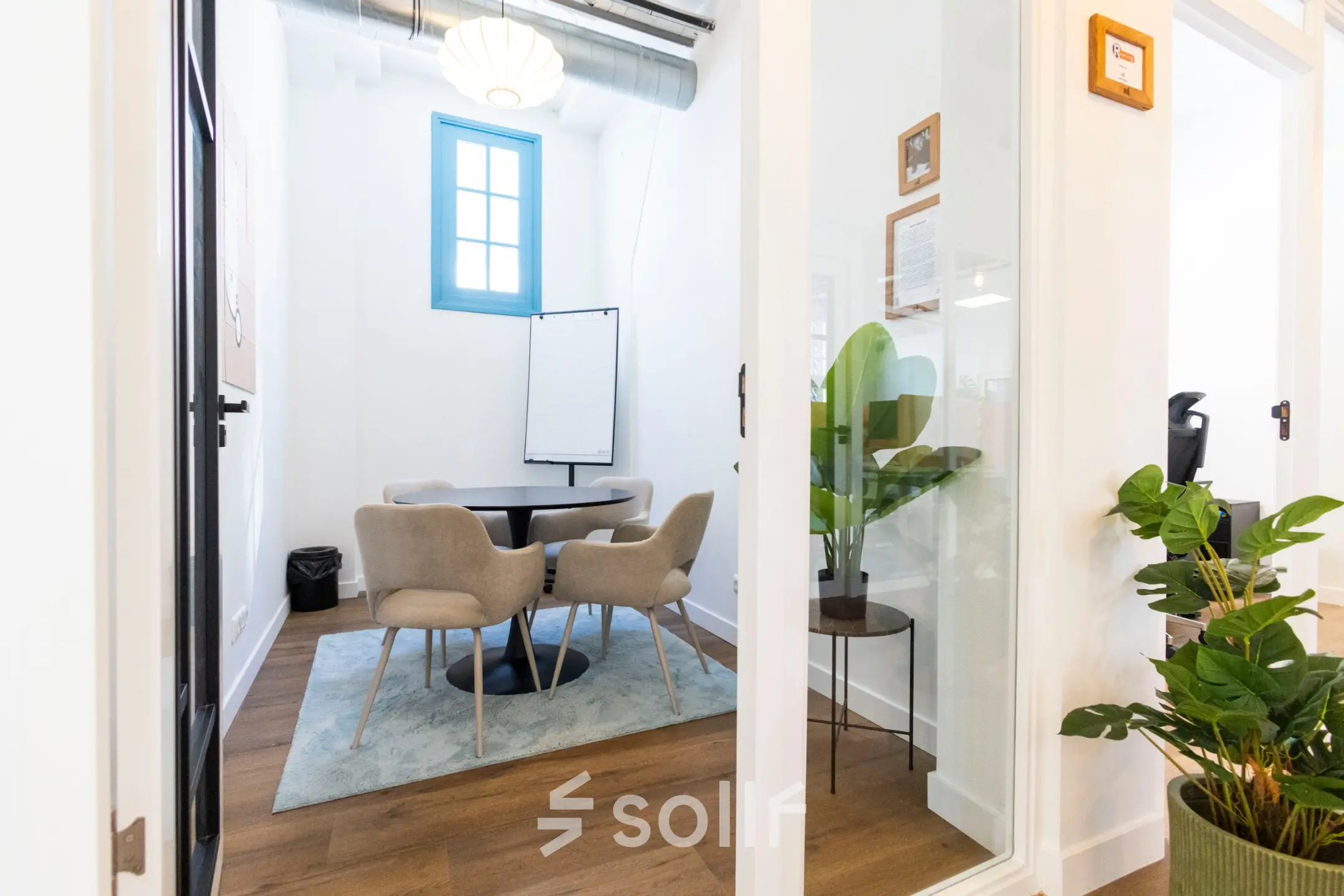 Bright office to rent at Oudegracht 161, Utrecht Center, featuring a small conference table surrounded by modern chairs and a flip chart in a cozy corner.