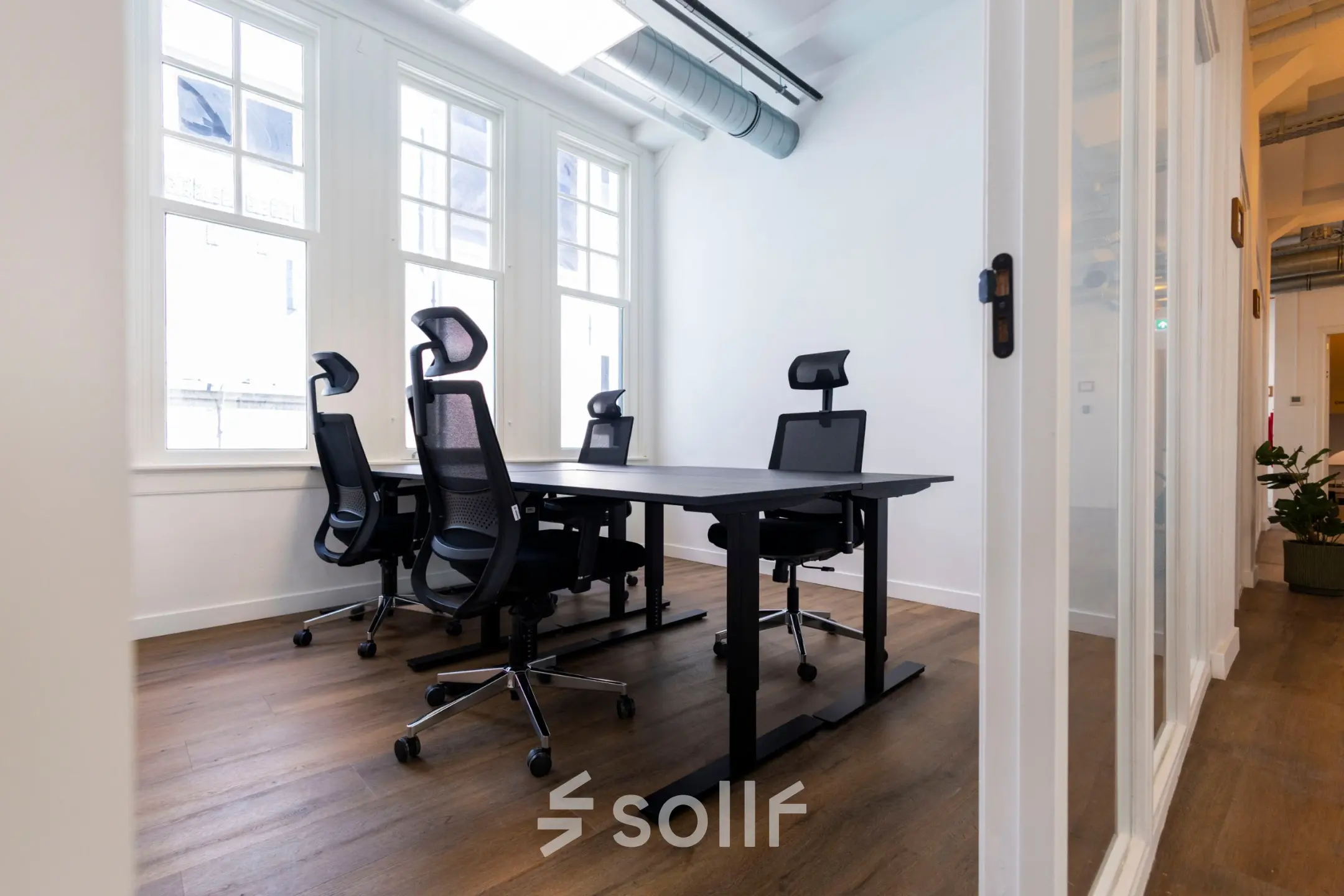 Bright office space rental at Oudegracht 161, Utrecht Center, featuring modern desks and chairs with natural light streaming in.