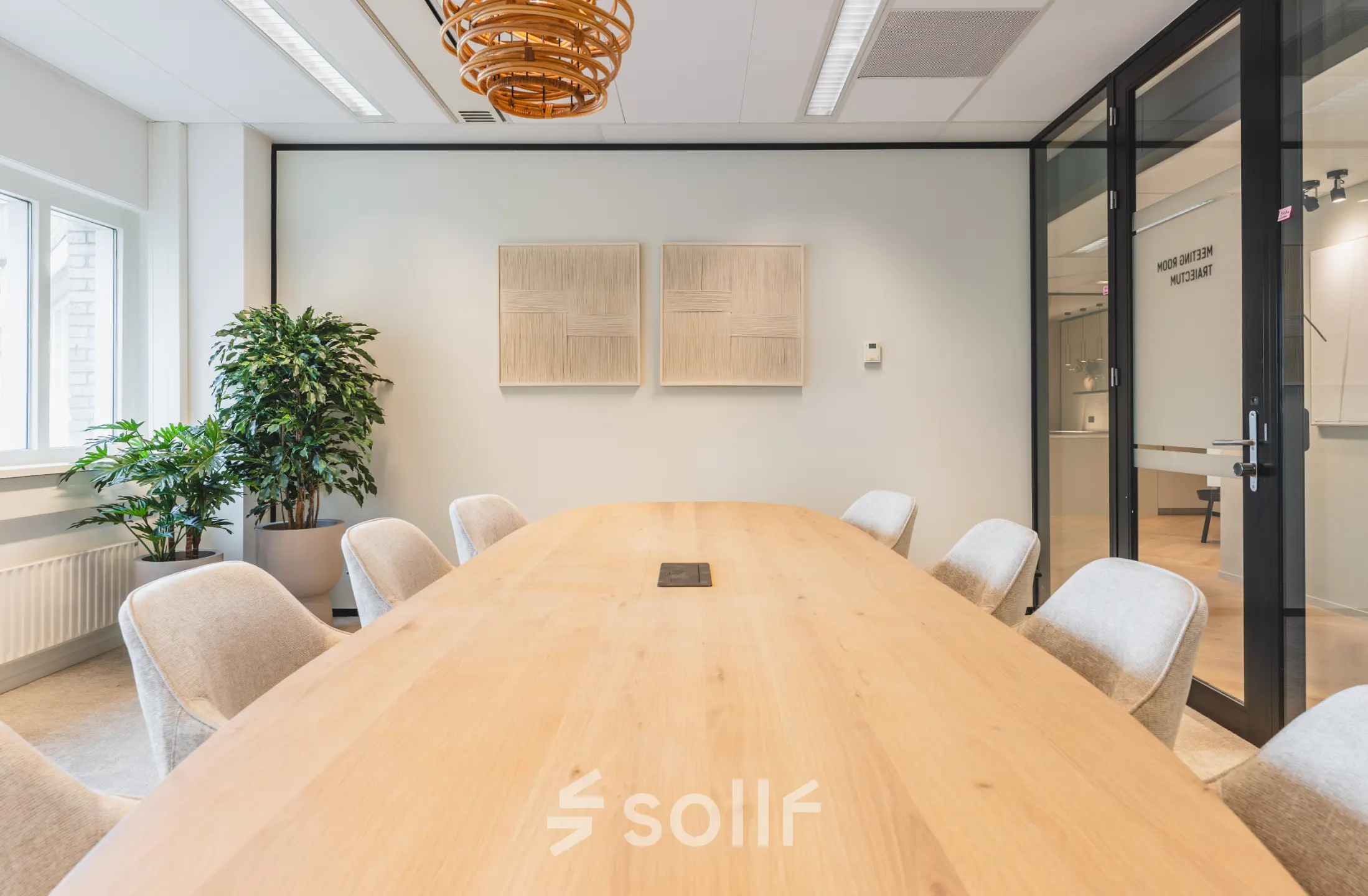 Modern conference room with a large wooden table and comfortable chairs, ideal for office space rental at Utrecht Central Station.