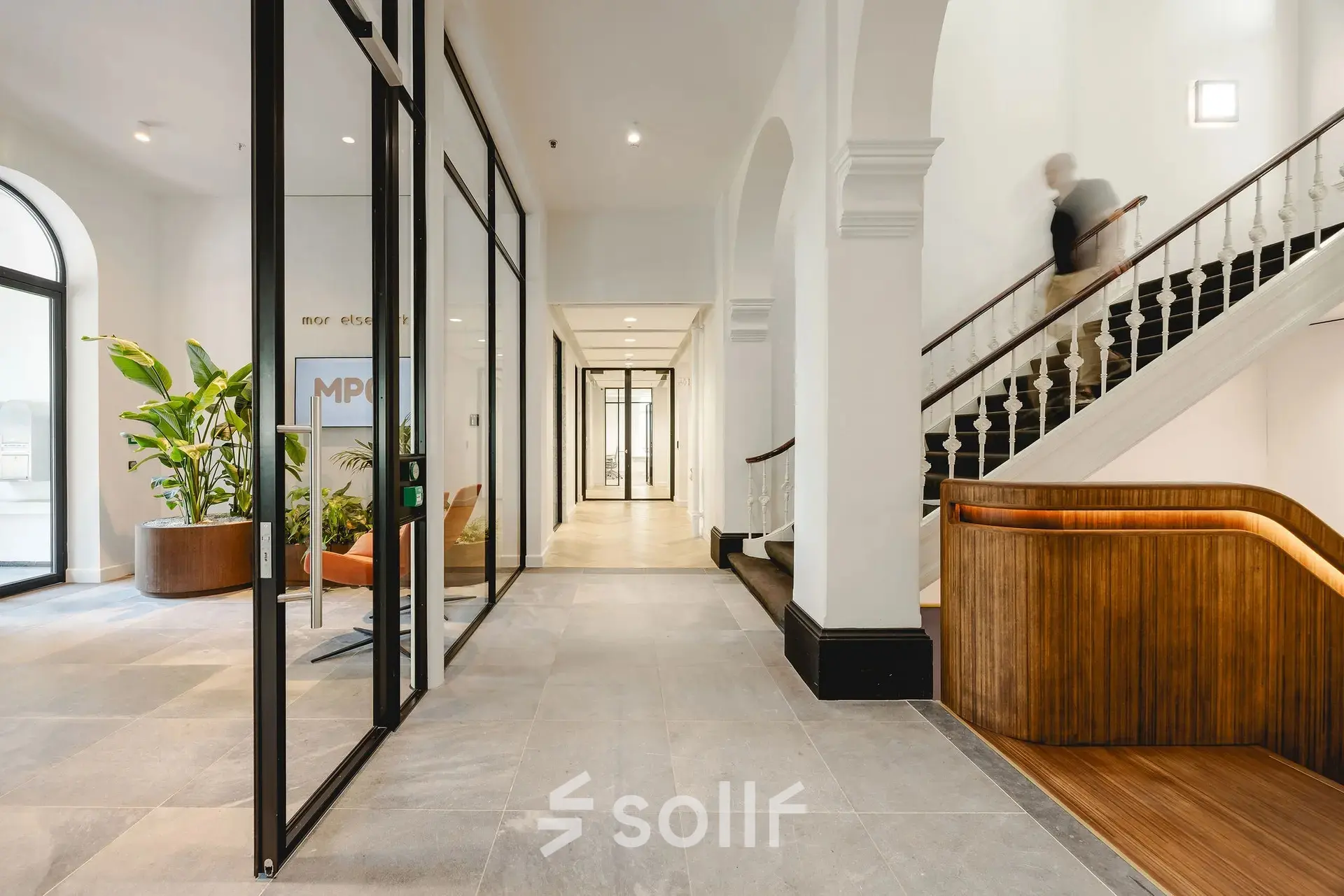 Spacious office entrance with modern design, featuring glass partitions and elegant wooden accents, located at Moreelsepark 1. Ideal office space rental opportunity in Utrecht Central Station.