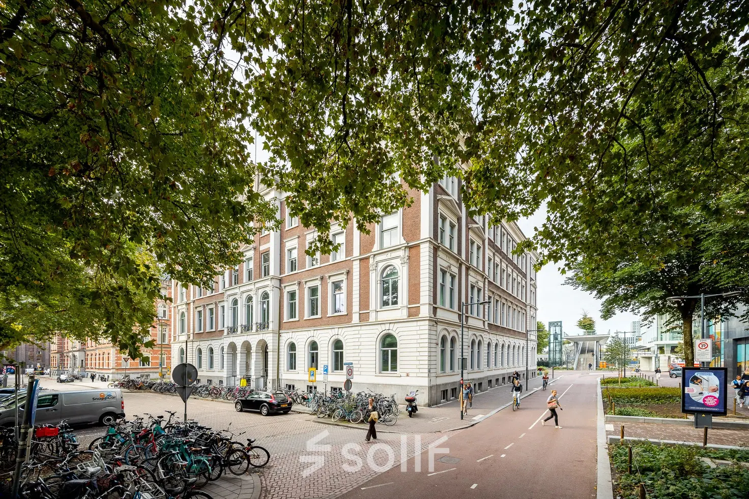 Exterior view of office building at Moreelsepark 1, Utrecht Central Station, showing a potential office to rent amidst a bustling urban environment.
