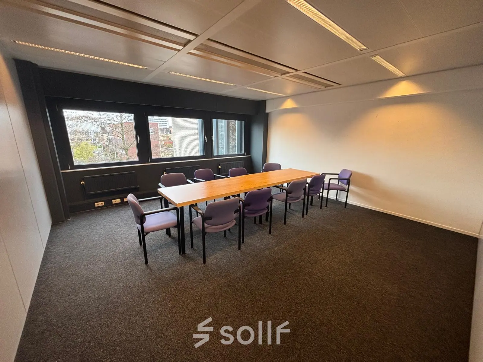 Spacious office to rent in Utrecht Kanaleneiland at Bernadottelaan 13 with a large wooden table surrounded by purple chairs, ideal for meetings.