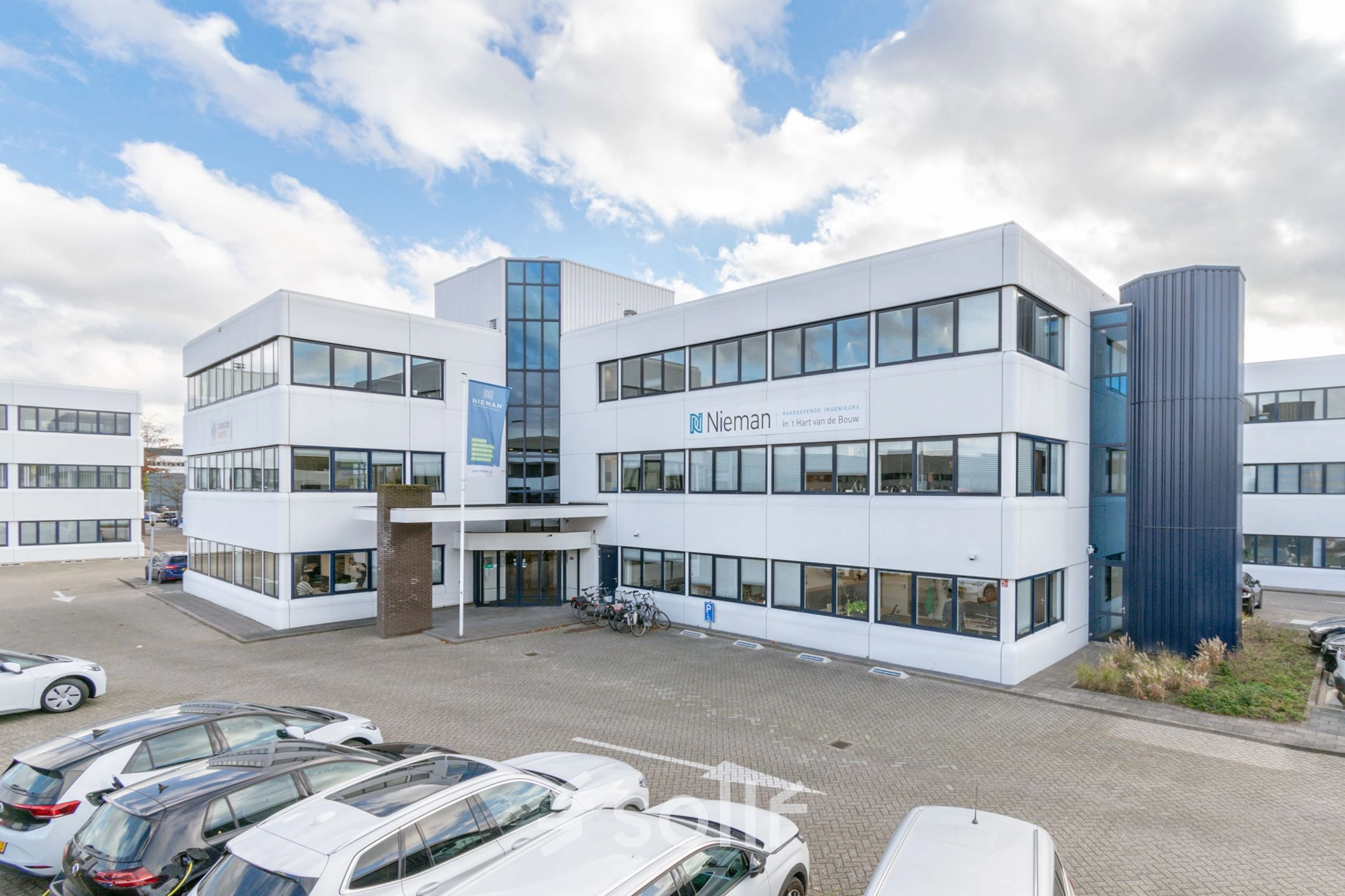 Exterior view of the office building at Atoomweg 350 in Utrecht Lage Weide, showcasing the entrance and parking area.
