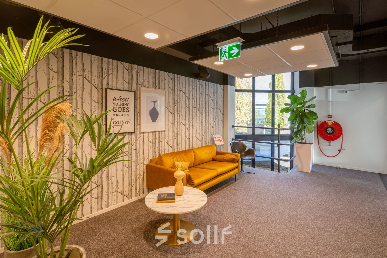 Bright office lounge at Atoomweg 400 with a cozy yellow sofa and a coffee table, ideal for office space rental in Utrecht Lage Weide.