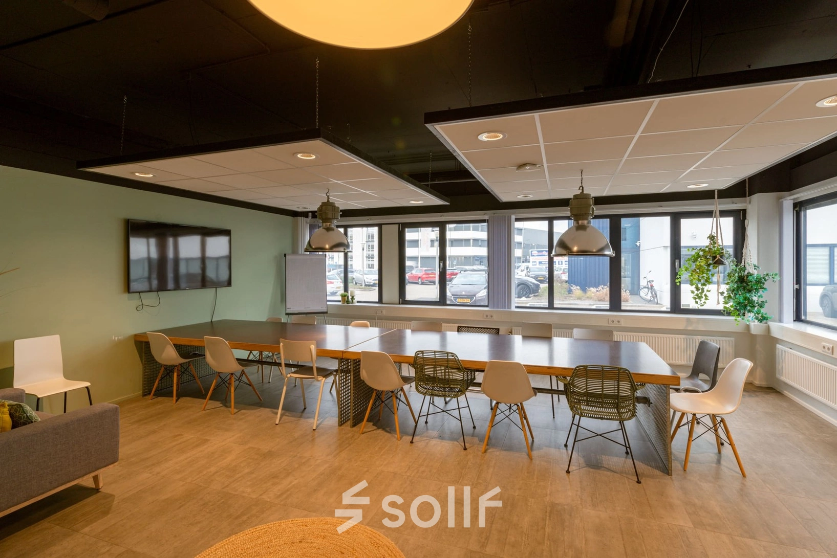 Spacious meeting room at Atoomweg 400 in Utrecht Lage Weide, featuring a large table with chairs, ideal for office space rental and collaborative work. Modern lighting and a wall-mounted screen enhance functionality.