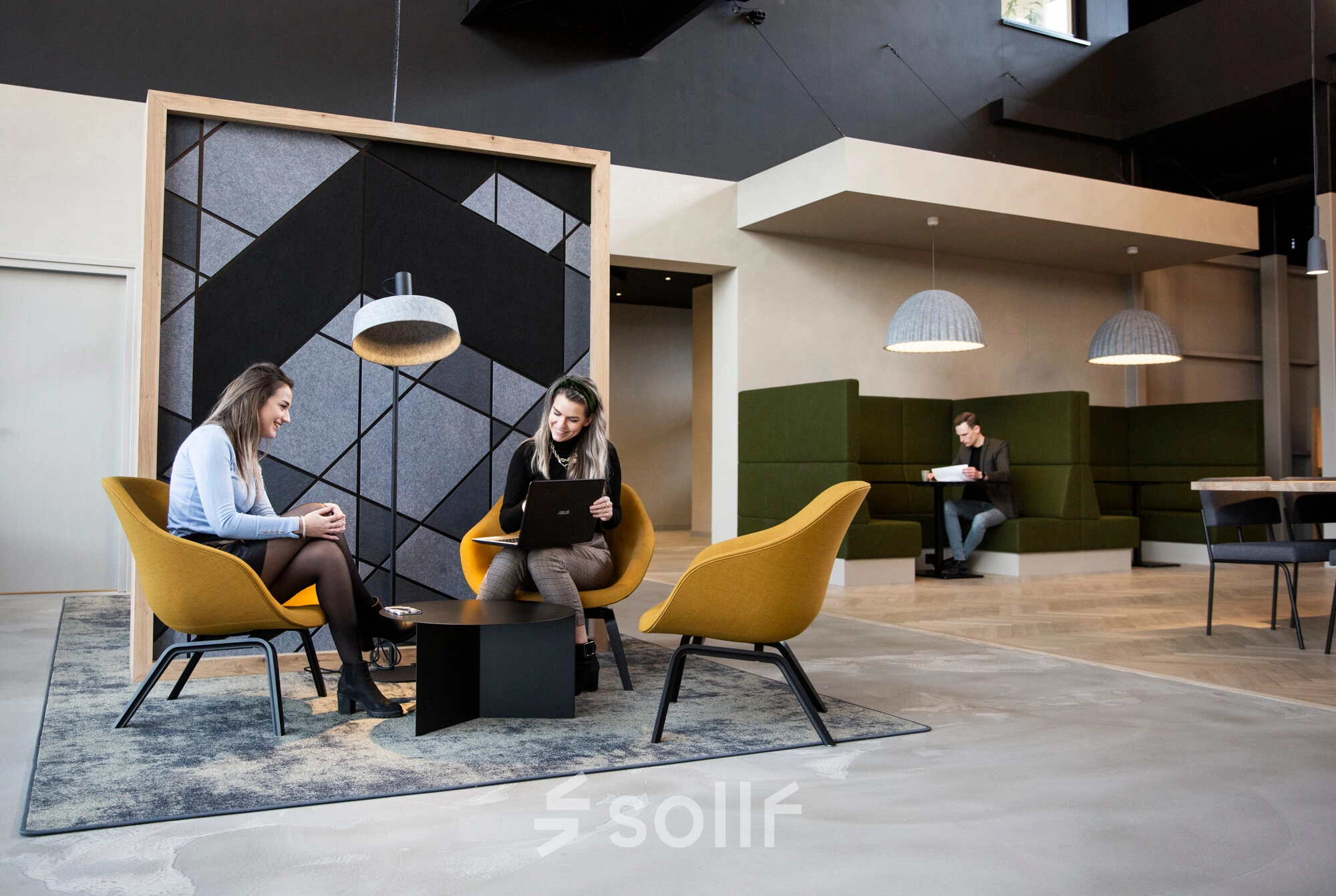 Modern office lounge at Atoomweg 63, Utrecht Lage Weide, featuring comfortable seating and individuals engaged in business activities, ideal for office space rental.