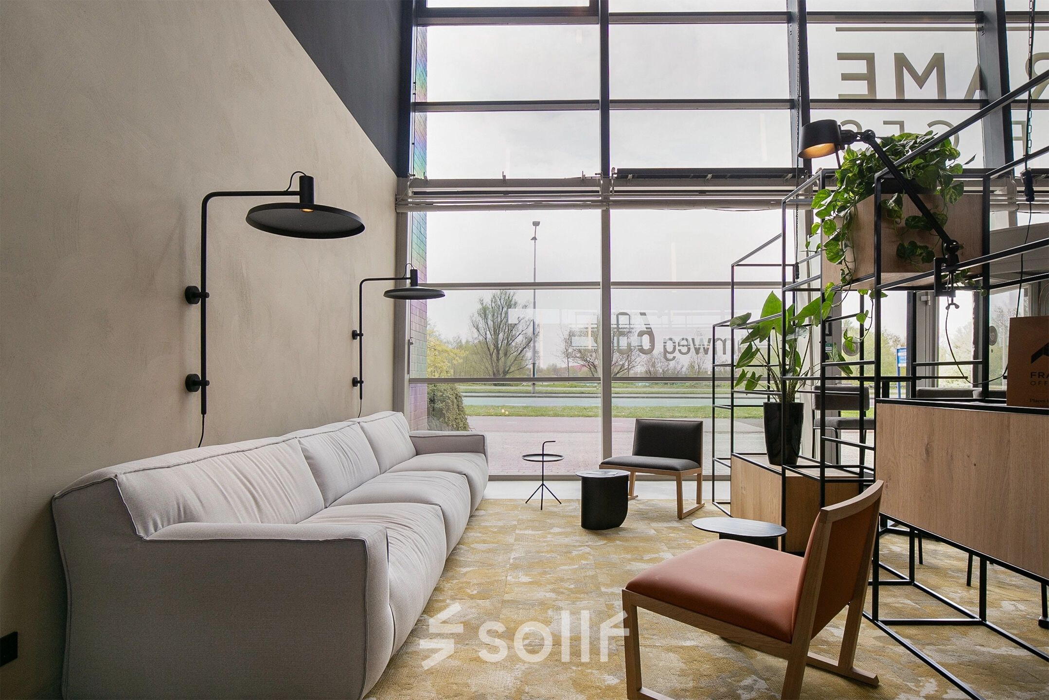 A modern, furnished office lounge space at Atoomweg 63, Utrecht Lage Weide, featuring comfortable seating, stylish decor, and large windows providing natural light. Ideal for rent office space seekers.