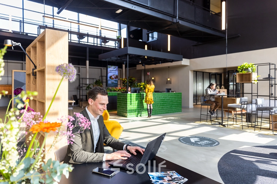 Modern office space for rent at Atoomweg 63, Utrecht Lage Weide, featuring bright, open workspaces with people engaged in various business activities.