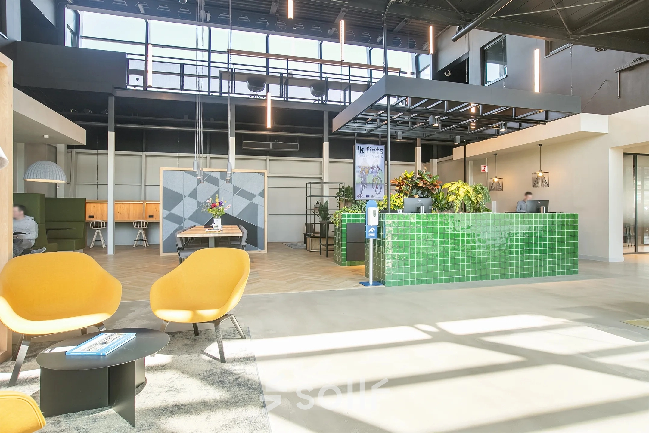 Bright office interior at Atoomweg 63, Utrecht Lage Weide, showcasing furnished open floorplan with inviting seating area and green reception desk, ideal for office space rental.