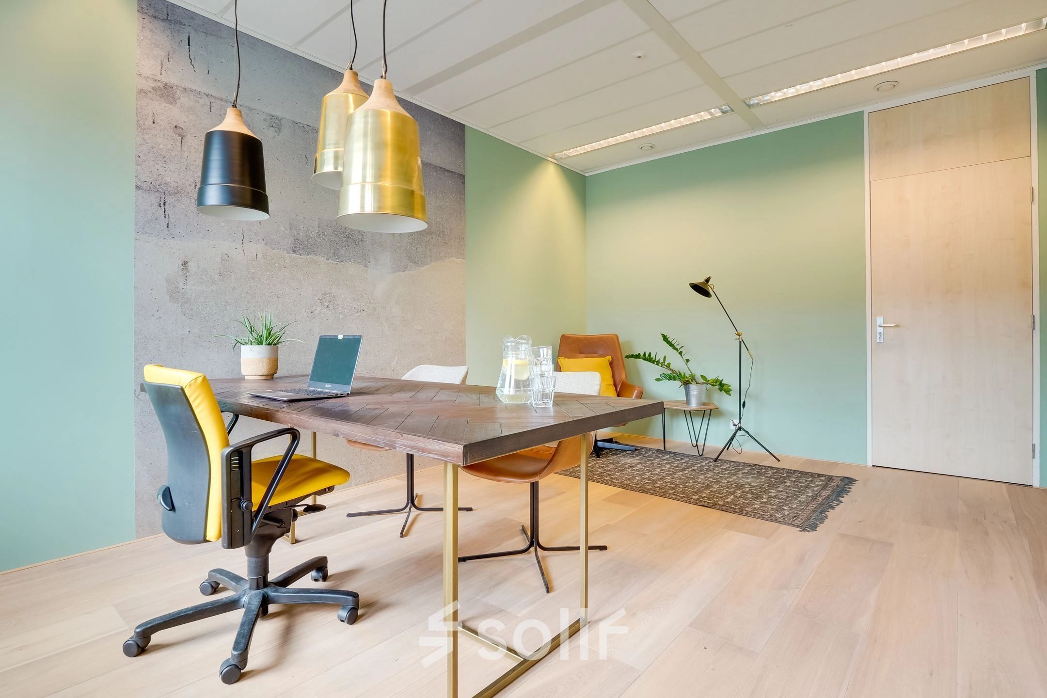 A bright and modern office space with stylish furnishings, located at Computerweg 22 in Utrecht Lage Weide, available for rent. Features a workspace with chairs, table, and plants.