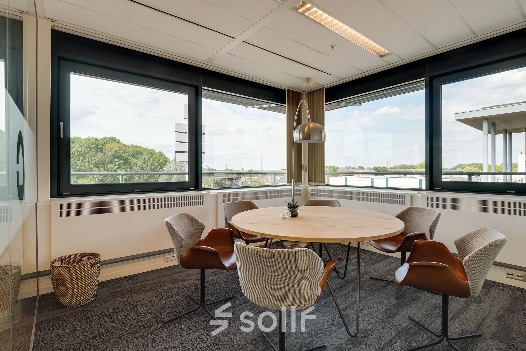 Bright office space at Computerweg 22 in Utrecht Lage Weide featuring a round table with five chairs and large windows offering ample natural light.