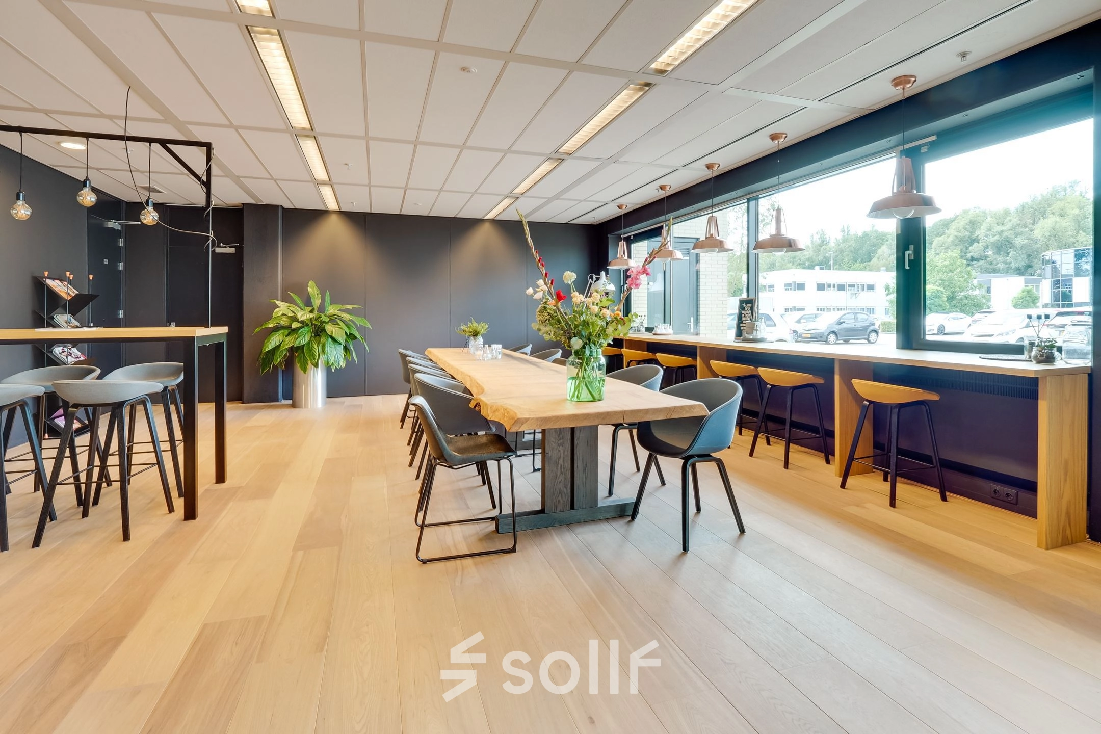 Modern office space in Utrecht Lage Weide featuring a spacious, furnished interior with large windows and a mix of seating areas, ideal for working or meetings.