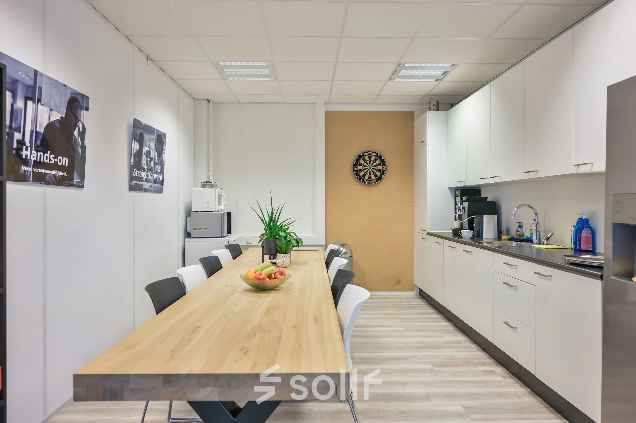 Bright, furnished office space at Kobaltweg 11 in Utrecht Lage Weide with a long table, chairs, and kitchen facilities available for rent.