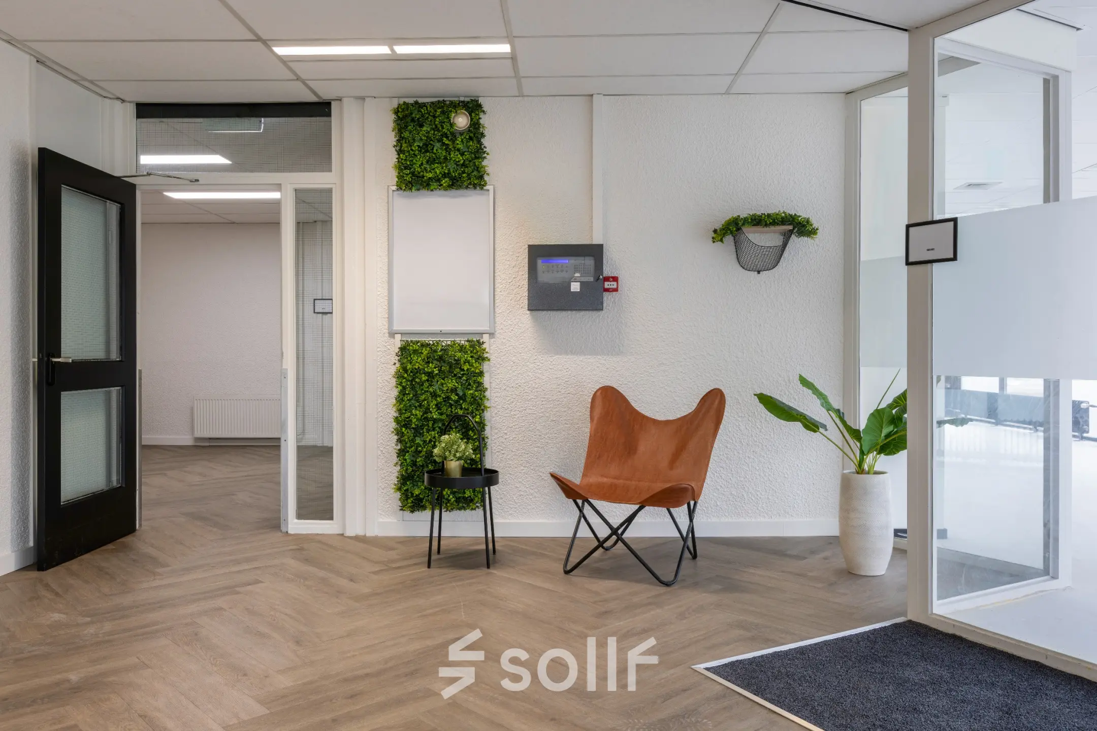 Modern office entrance at Zonnebaan 18, Utrecht Lage Weide, featuring chic seating, greenery, and sleek flooring, ideal for office space rental.