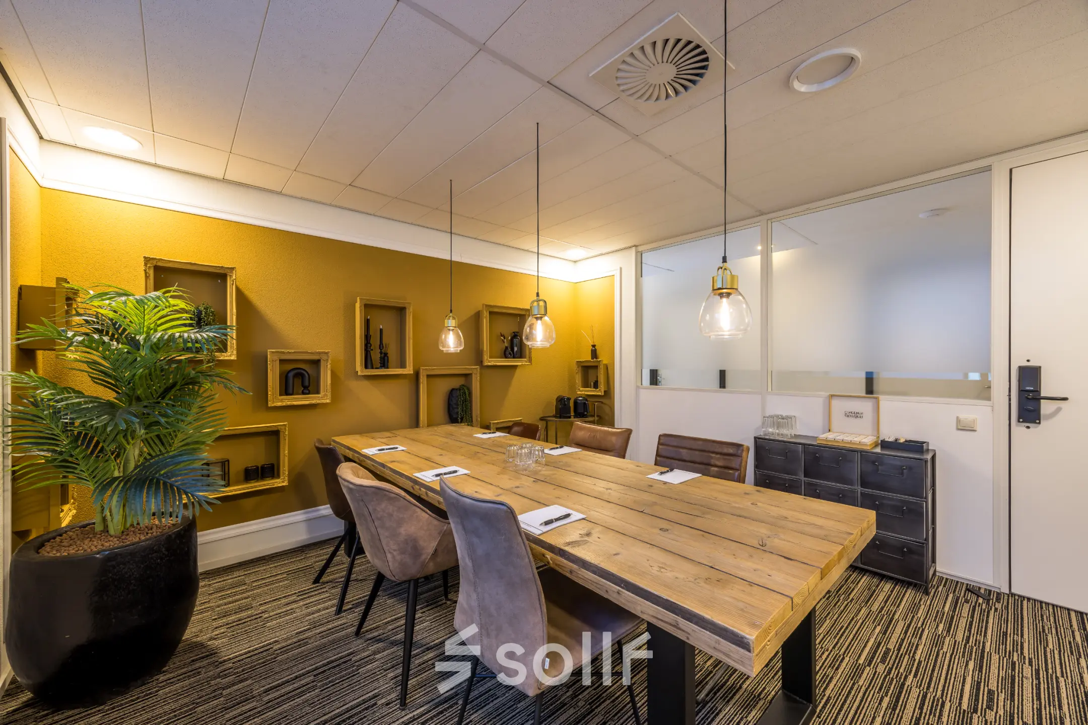 Modern office space with a wooden table and chairs for meetings, located at Goeman Borgesiuslaan 77. Ideal for office space rental needs in Utrecht North.