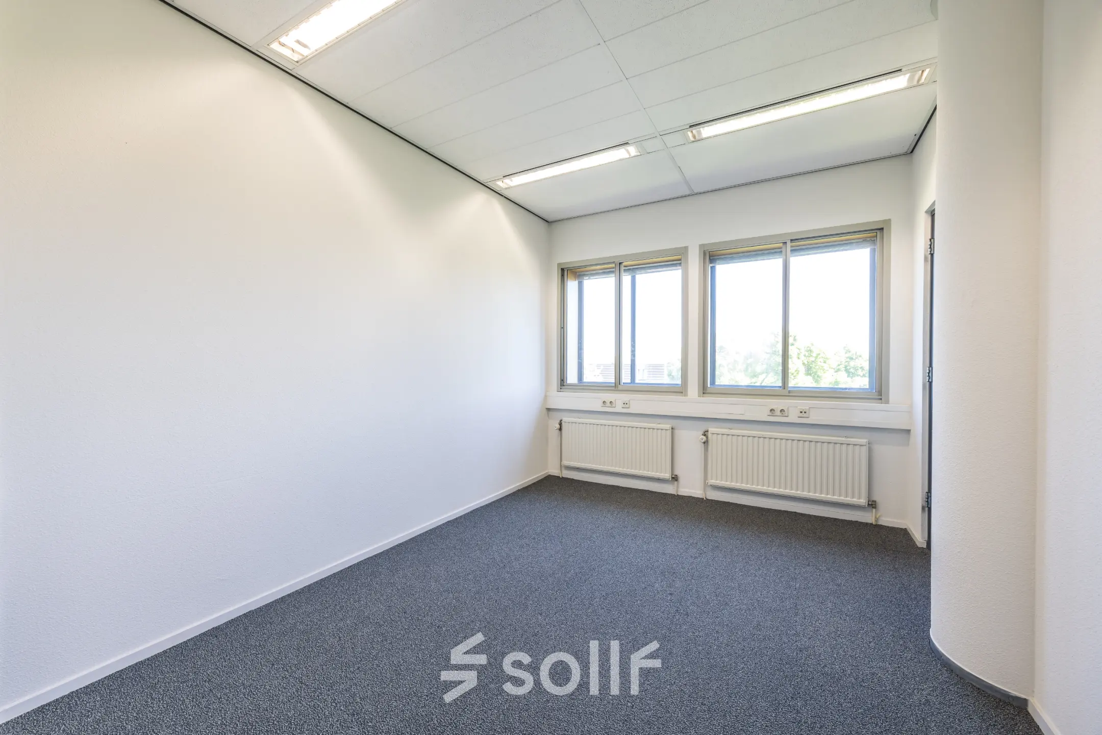 An unfurnished office space with natural light filtering through large windows, located at Goeman Borgesiuslaan 77 in Utrecht North, perfect for office space rental.