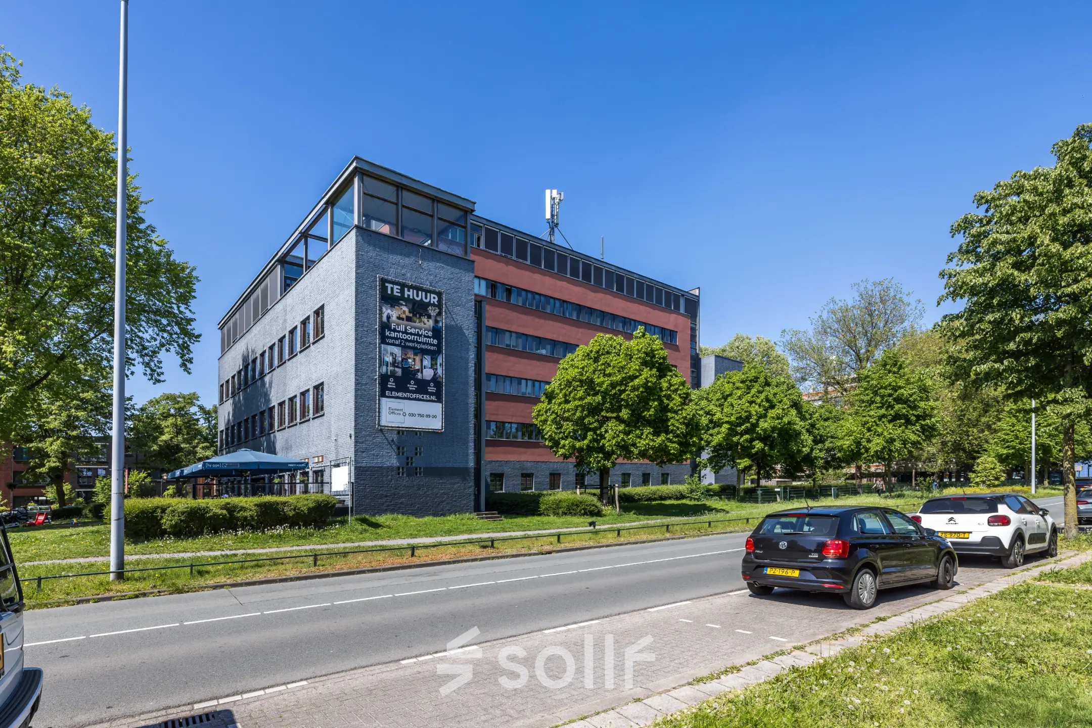 Exterior view of office building at Goeman Borgesiuslaan 77 in Utrecht North, set against a clear sky, with 'te huur' sign visible.