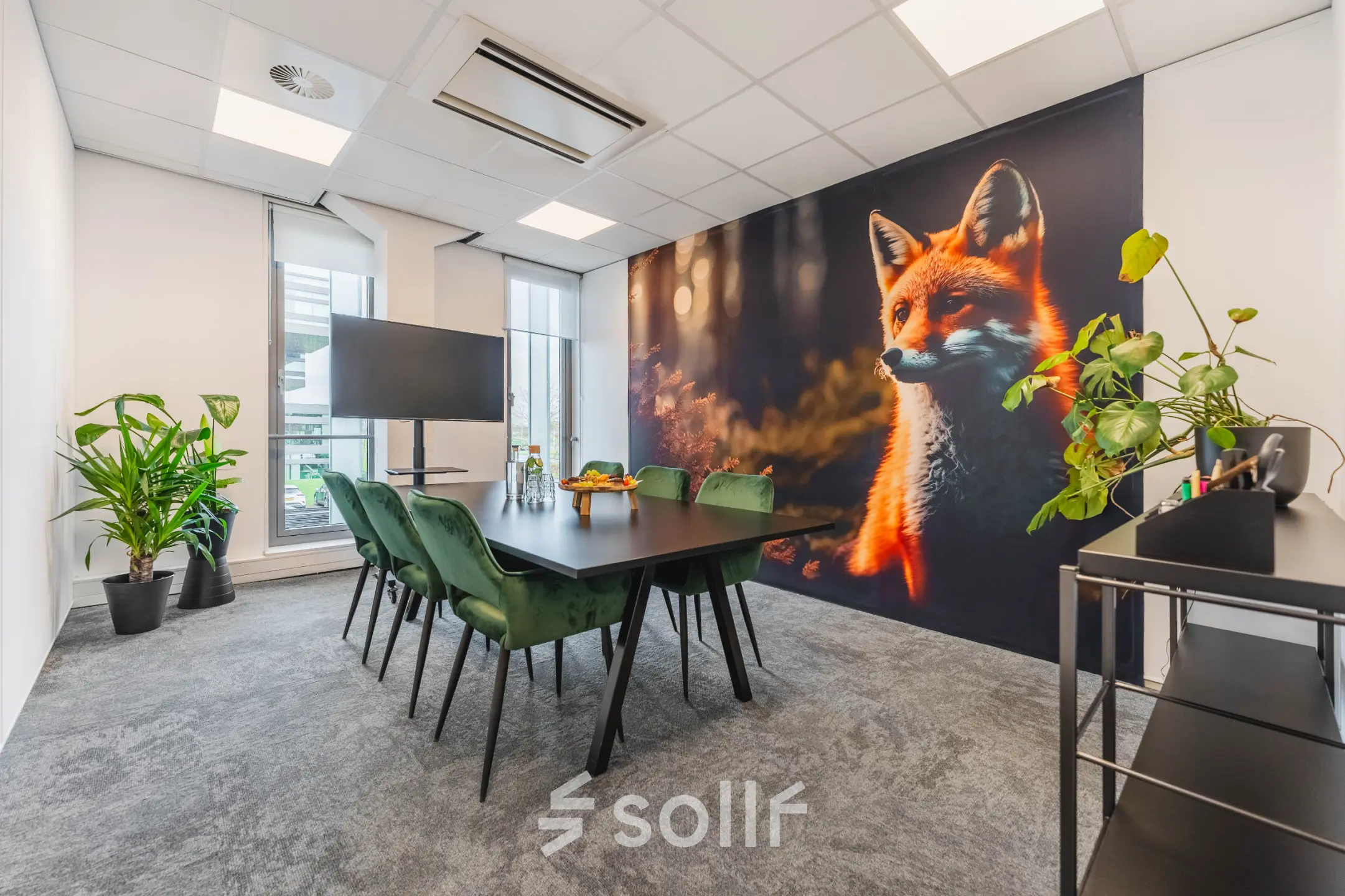 Bright office space for rent in Utrecht Papendorp featuring a large fox mural, conference table, chairs, and plants, offering a modern setup for meetings.