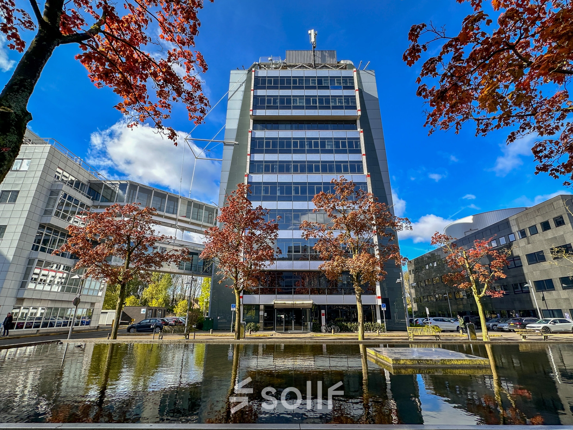 Exterior view of an office building at Daltonlaan 200 in Utrecht Rijnsweerd, featuring a clear sky and autumn trees. Ideal for businesses seeking office space rental.