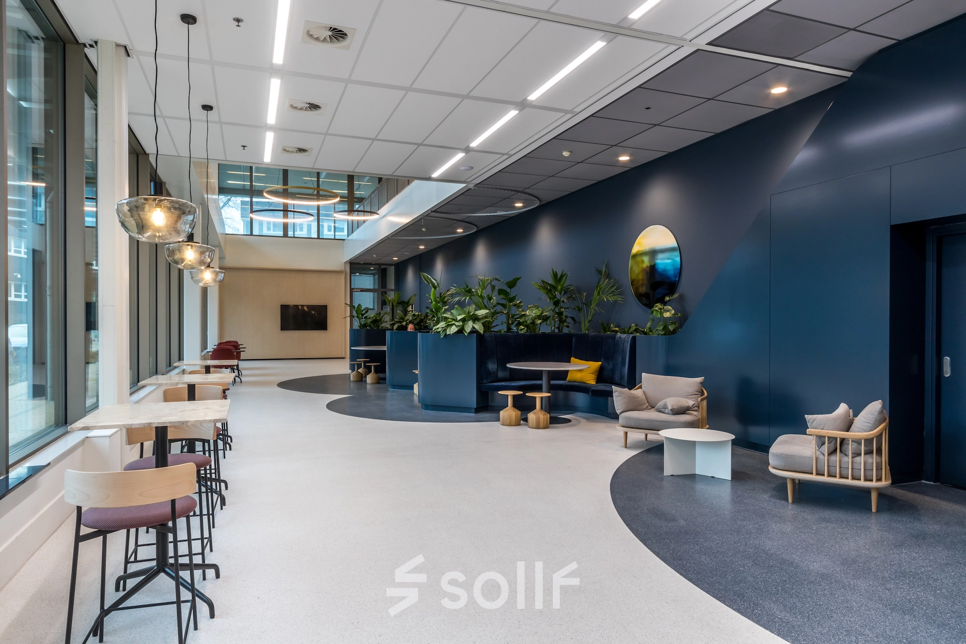 Modern office located at Vliegend Hertlaan 15, Utrecht South, with stylish furnishings including seating areas and lush greenery, ideal for office space rental.