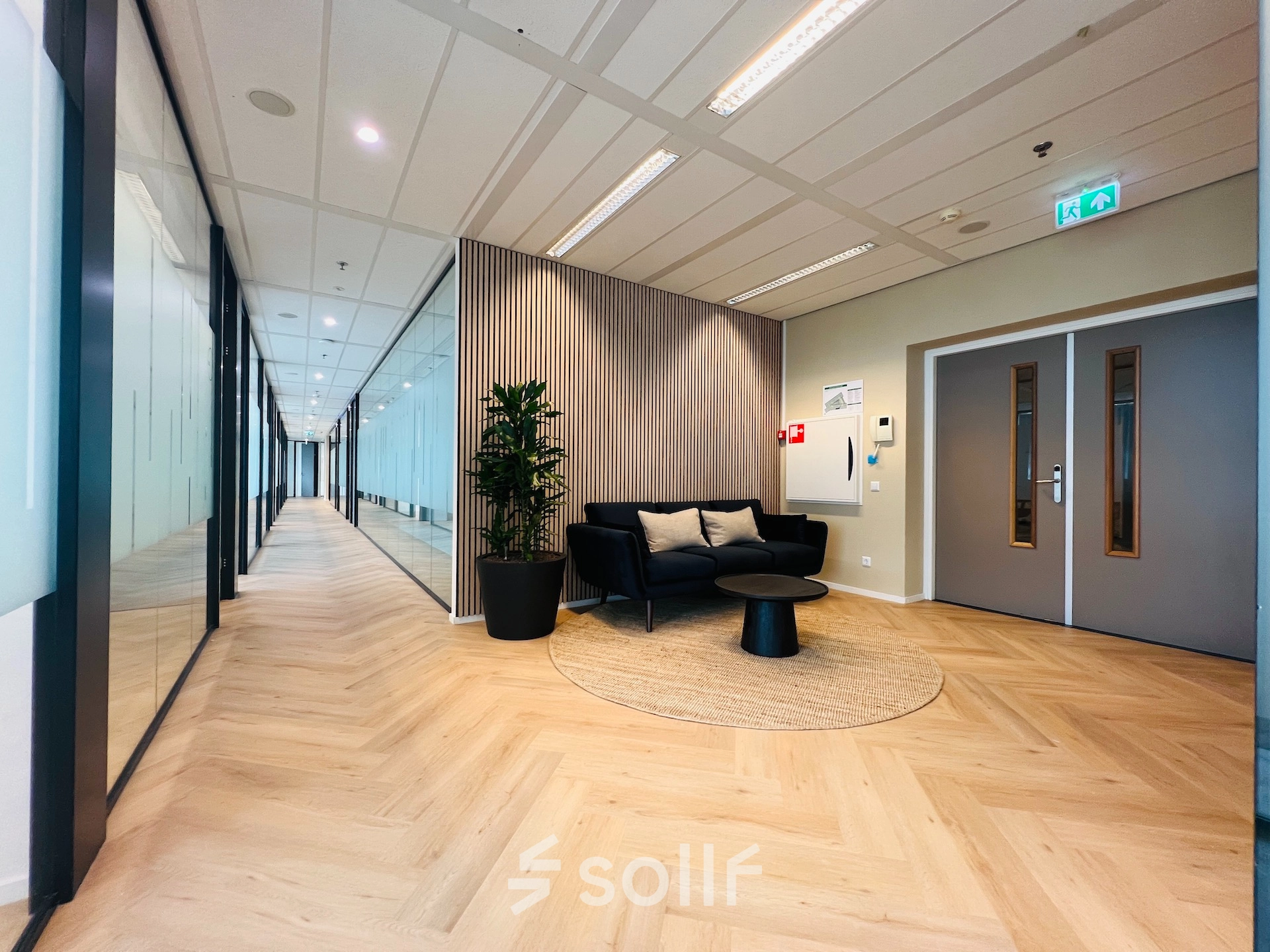 Modern office space in Utrecht South, ideal for rent, featuring a furnished corridor with cozy seating and stylish decor.