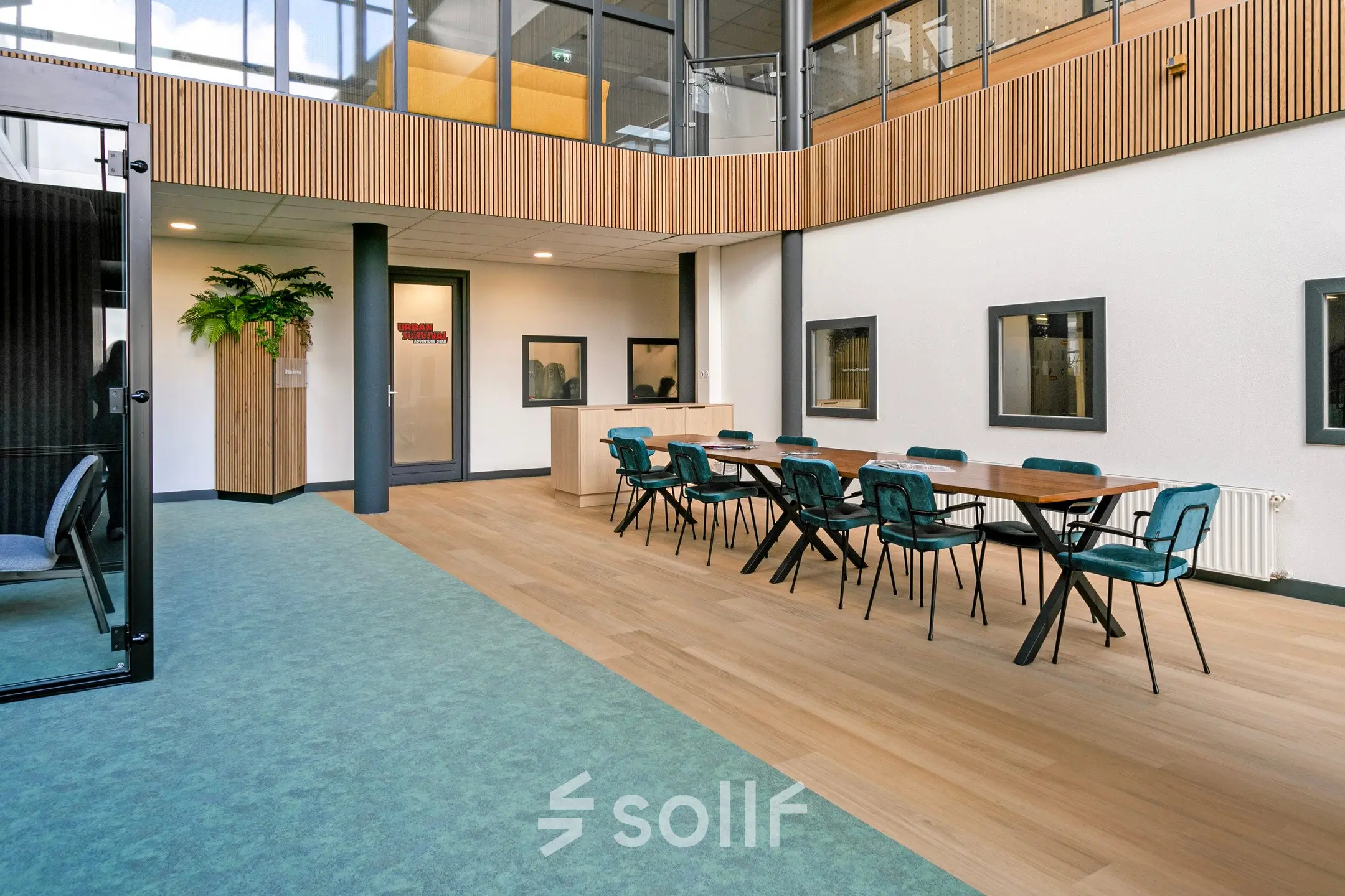 Modern office space rental featuring a spacious area with teal chairs and wooden table, surrounded by contemporary design elements at De Run 4312, Veldhoven.