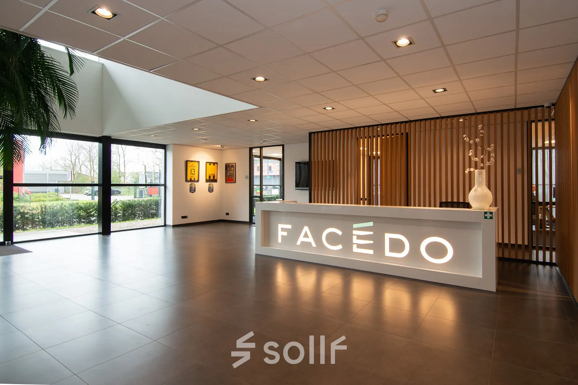Bright office lounge area at Gildestraat 13, Velp, featuring a modern reception desk and large windows, perfect for those looking to rent office space.