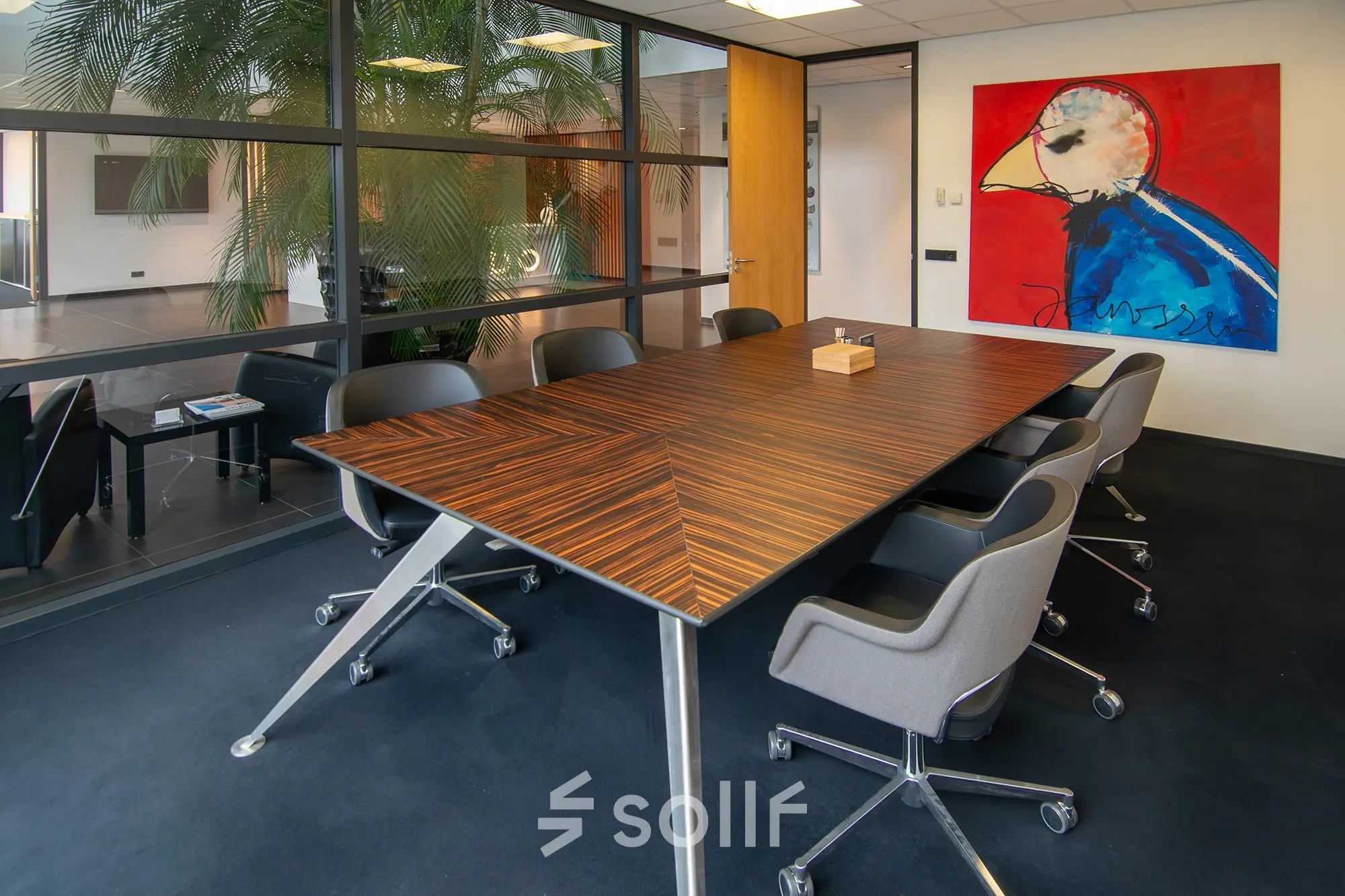 Office to rent at Gildestraat 13, Velp featuring a modern conference room with a large table and swivel chairs, showcasing vibrant artwork.
