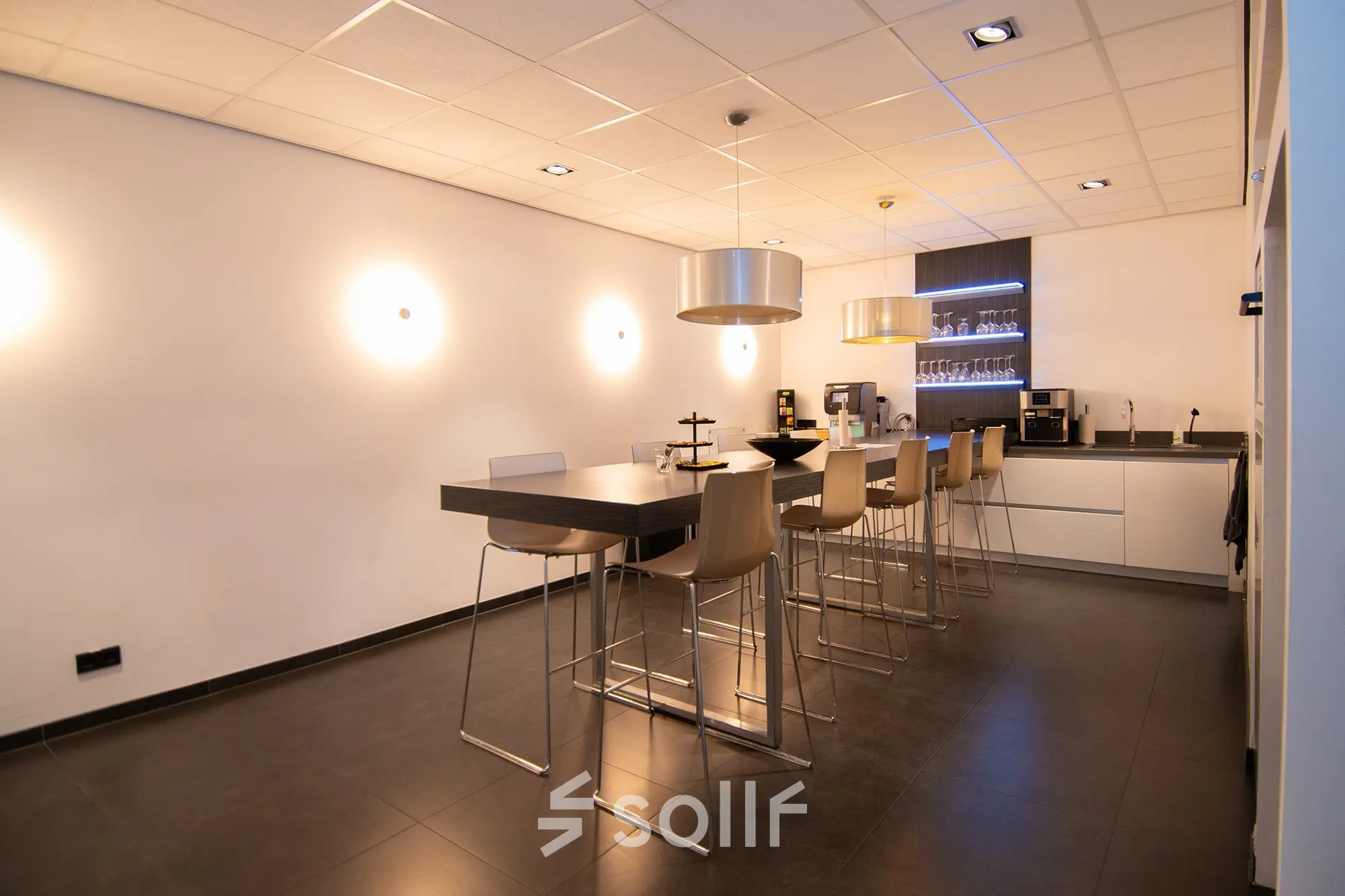 Modern office space rental at Gildestraat 13, Velp, featuring a sleek interior with high stools and a coffee area, perfect for informal meetings.
