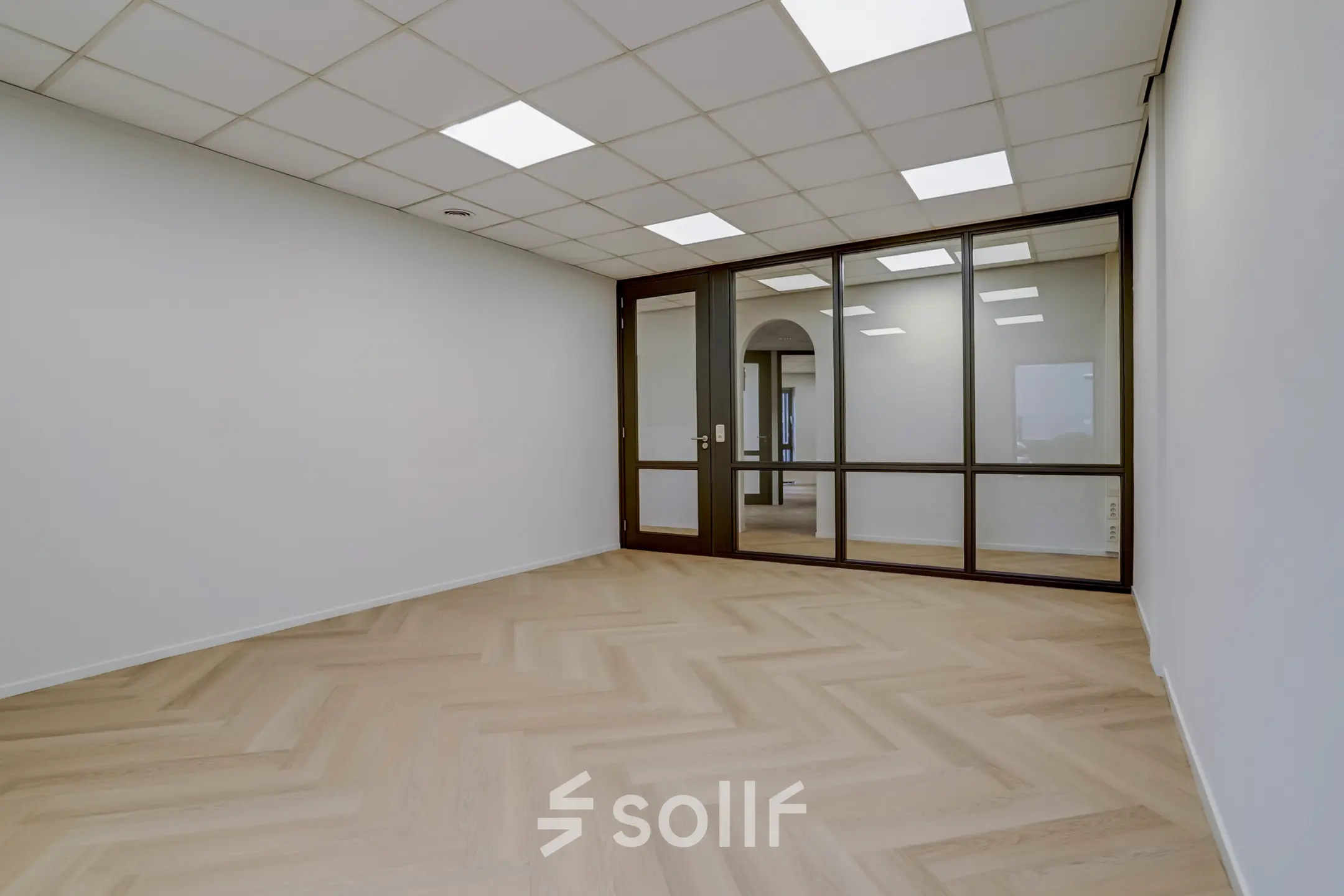 Vacant office space available for rent at Keizersveld 47 in Venray, featuring a modern interior with herringbone flooring and glass partitions, ideal for businesses seeking an office to rent.