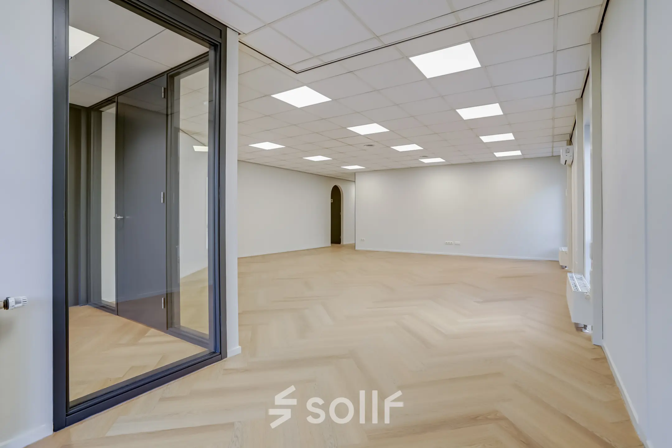 Unfurnished office space at Keizersveld 47, Venray, available for rent with large windows and wooden flooring, ideal for customization.
