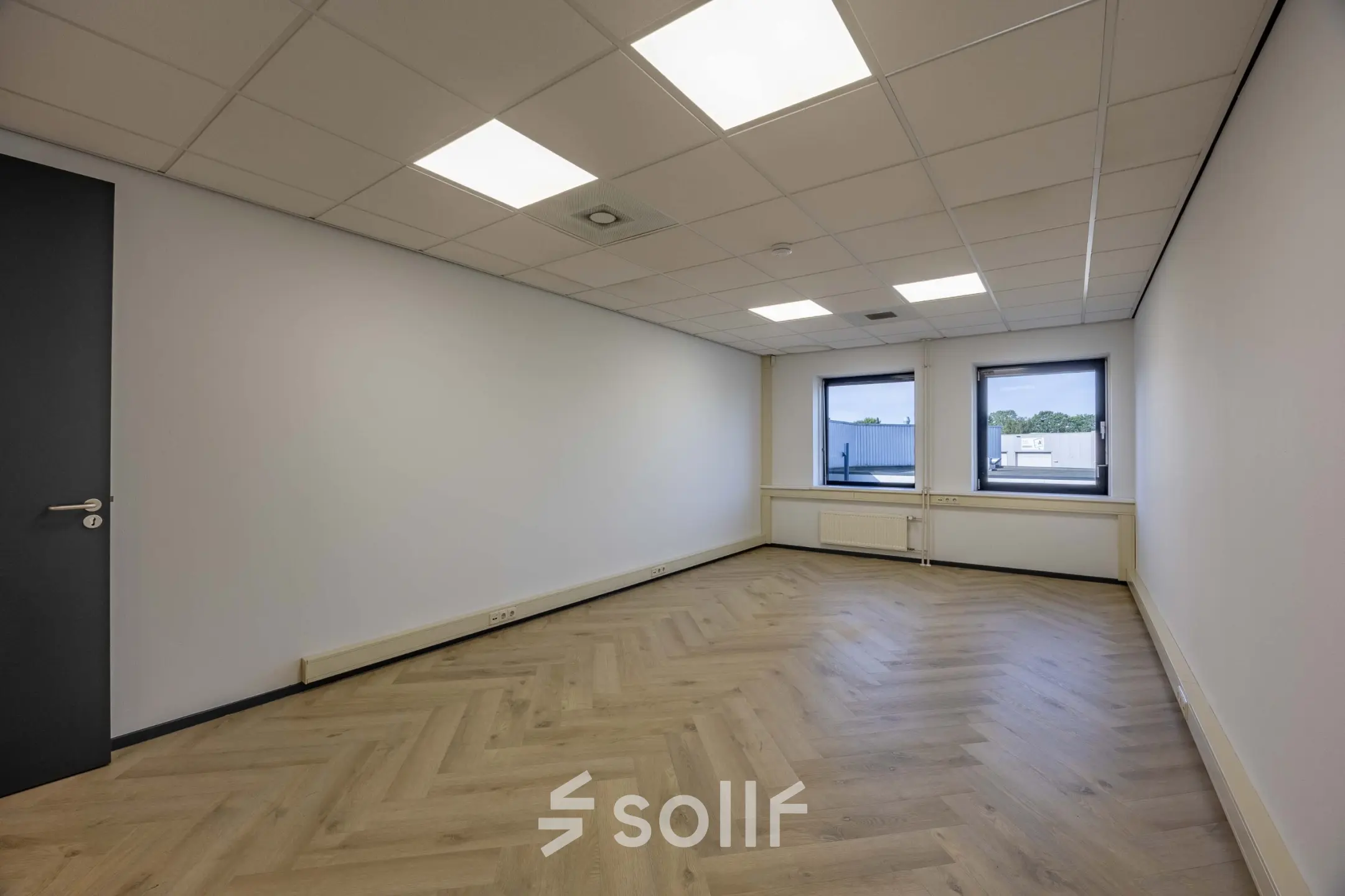 Spacious unfurnished office space with parquet flooring and large windows at Keizersveld 47 in Venray, ideal for office space rental.
