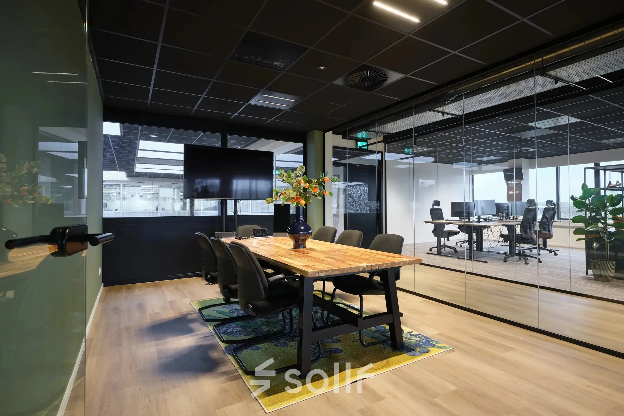 Modern office space with a glass-enclosed conference room, wooden table, and ergonomic chairs at Havenweg 24, ideal for those seeking office space rental in Vianen Utr.