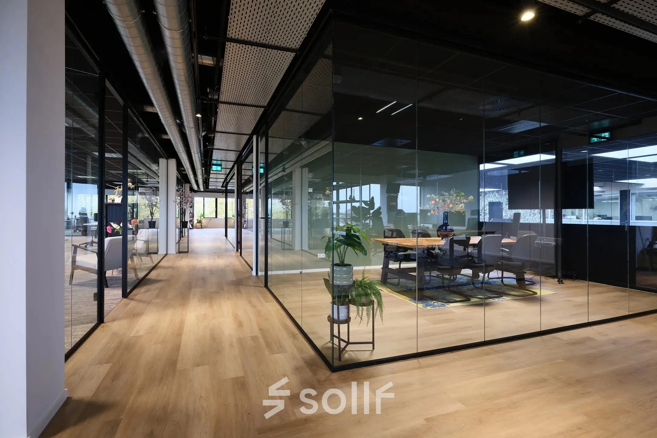 Modern office space with glass-enclosed conference rooms at Havenweg 24, Vianen Utr, highlighting seamless office space rental opportunities.