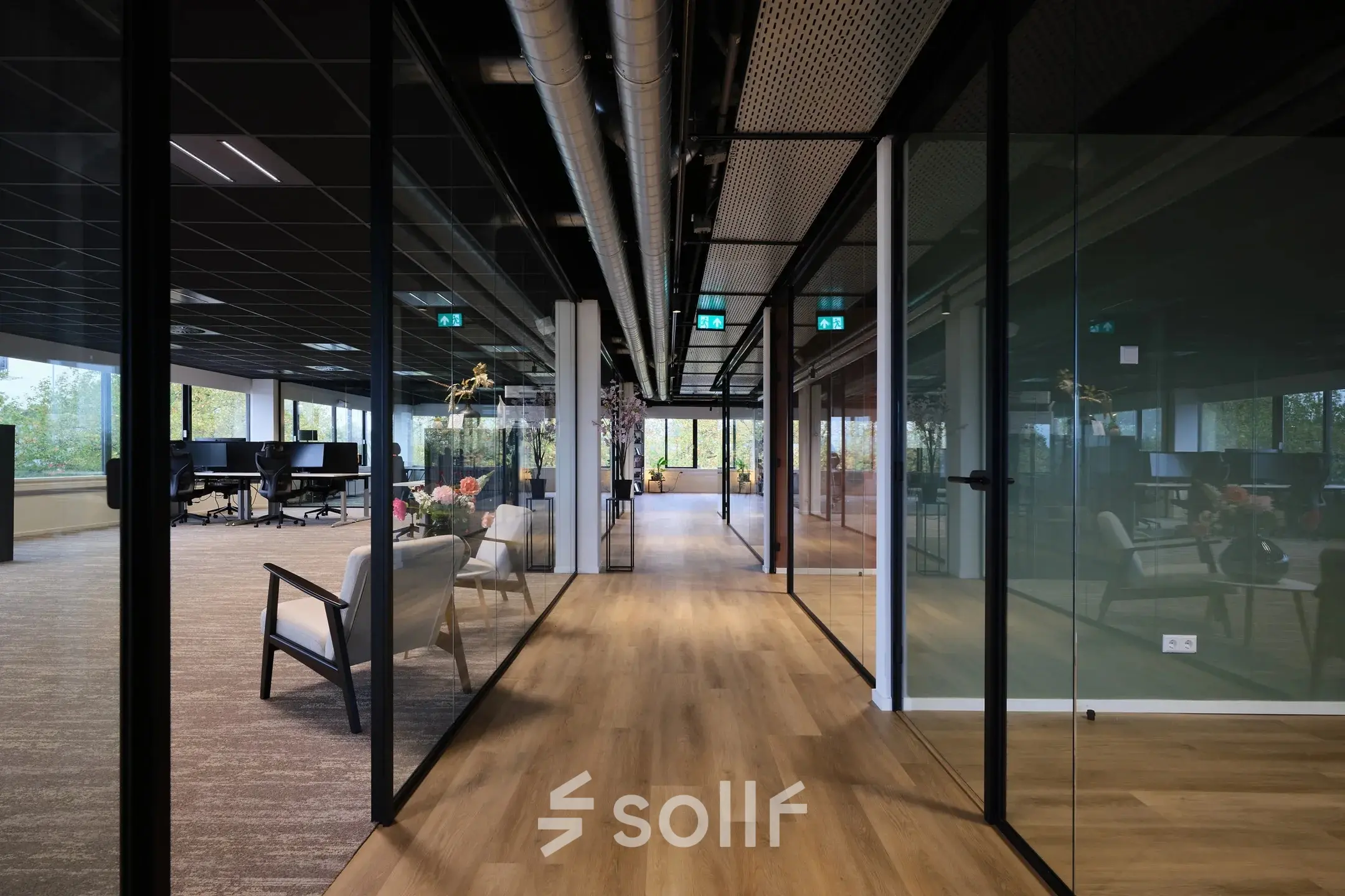 Modern office space with glass partitioned workspaces, featuring comfortable seating and a wooden floor at Havenweg 24, Vianen Utr, ideal for office space rental.