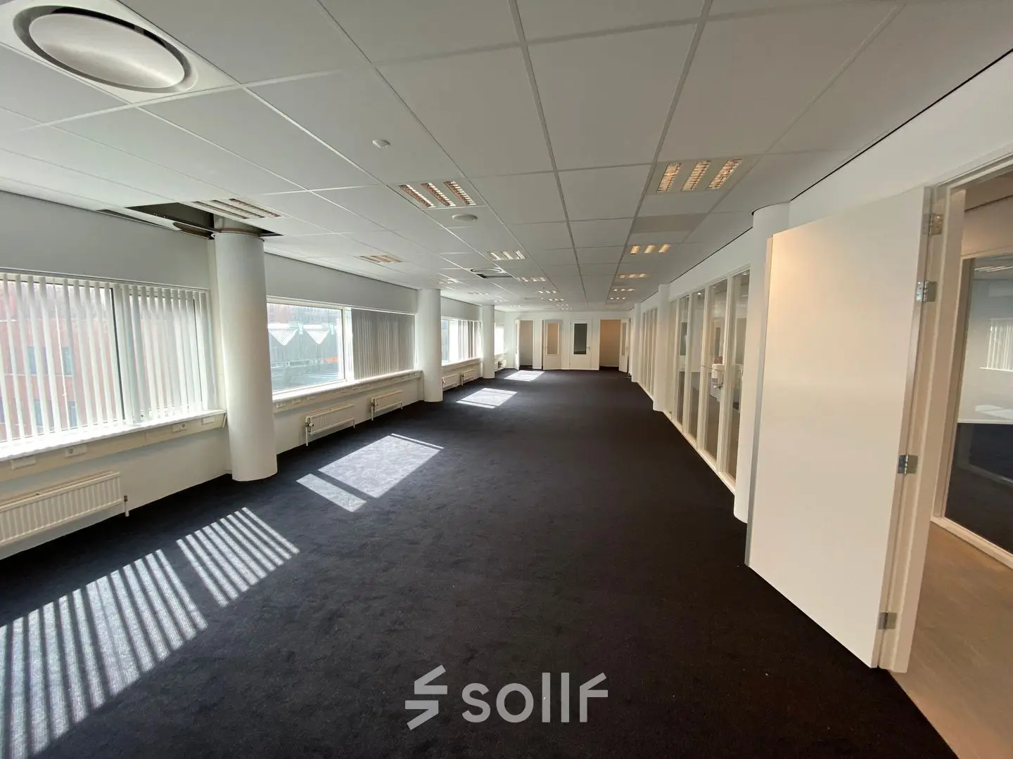 Spacious office to rent at Regulusweg 11, Voorburg, featuring large windows and a modern, open floorplan perfect for office space rental needs.