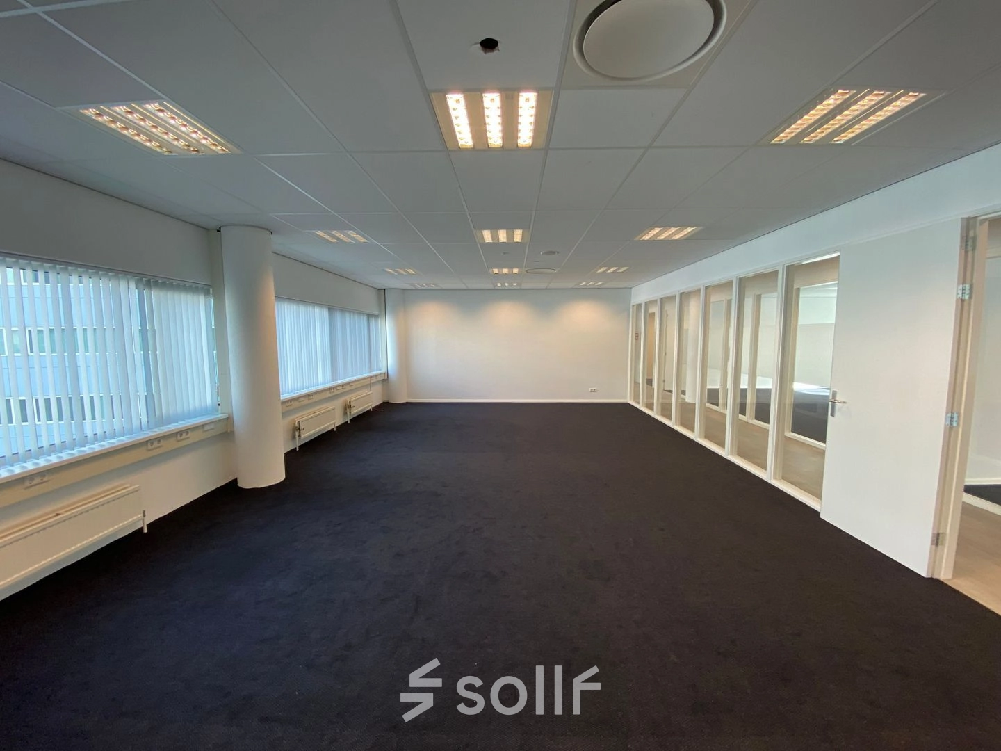 Spacious office to rent at Regulusweg 11, Voorburg, featuring large windows, neutral decor, and ample lighting, ideal for versatile workspace configurations.