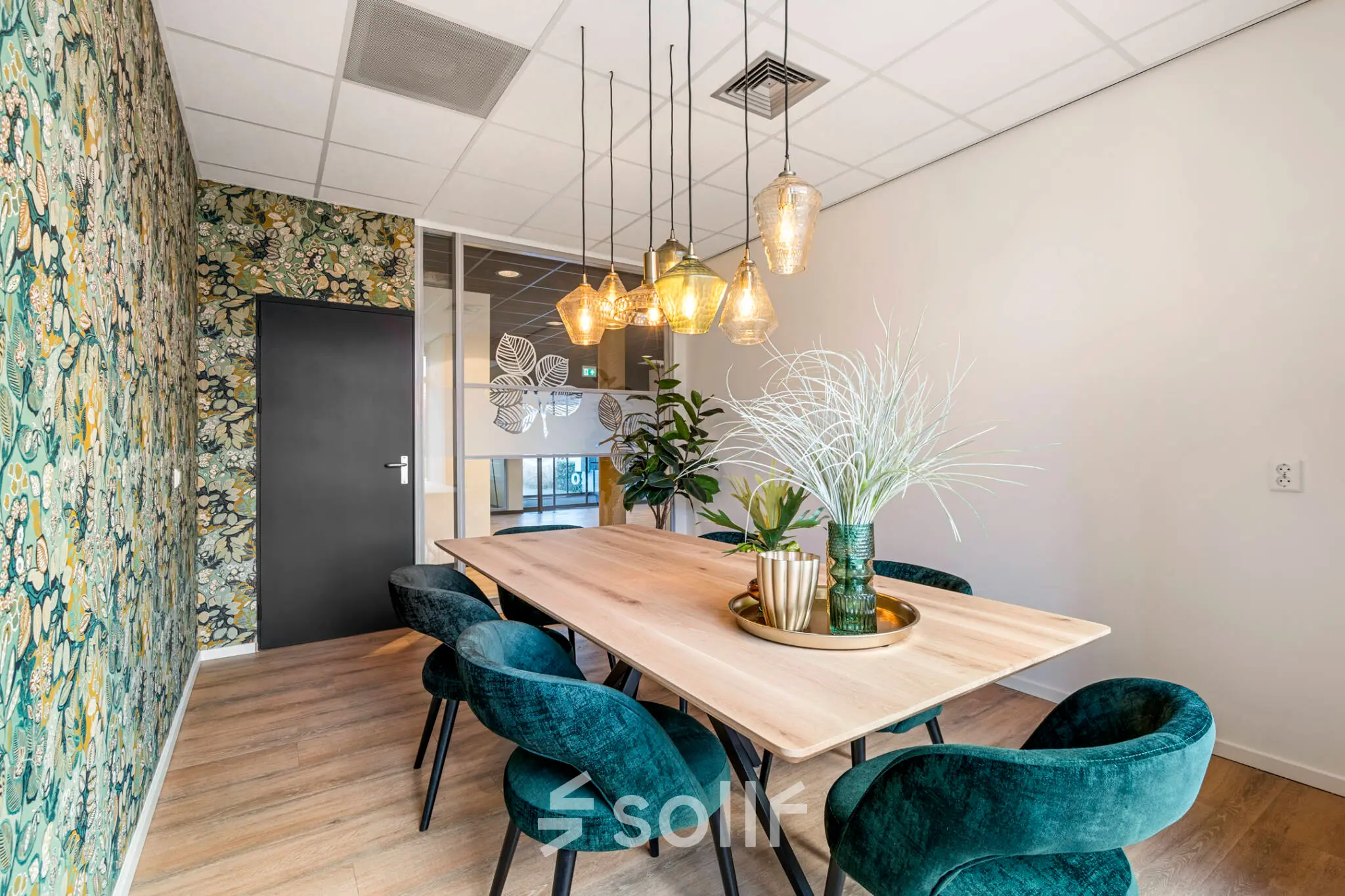 Stylishly furnished office space at Agro Business Park 22, Wageningen, ideal for rent. Features a modern table with chairs and decorative lighting, perfect for meetings.