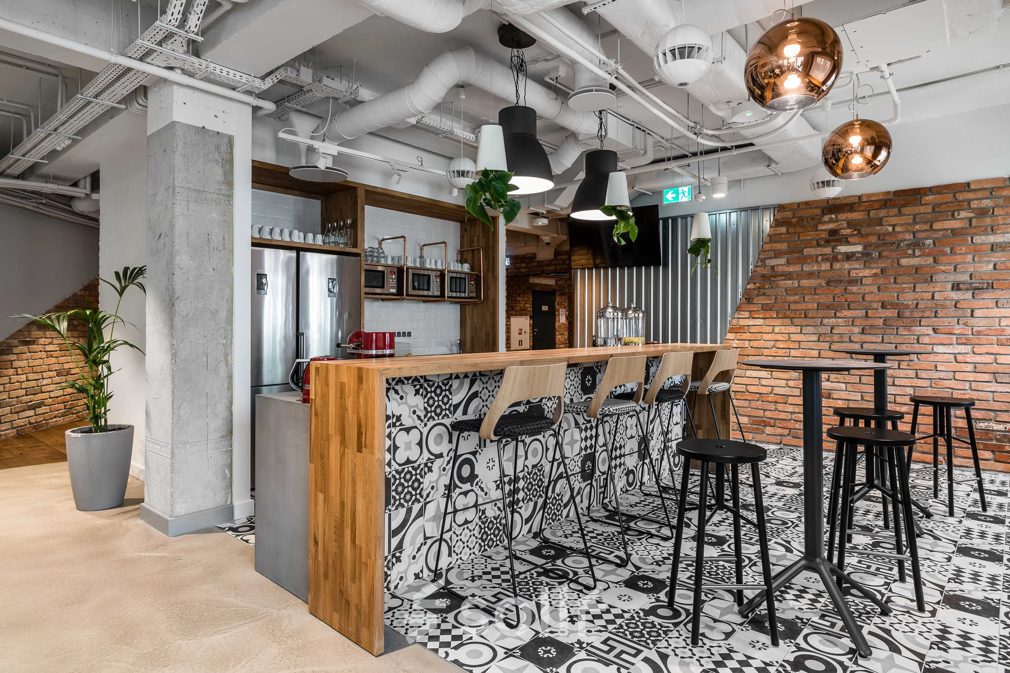 Modern office space located at Konstruktorska 11 in Warsaw Mokotow features a stylish lounge area with a bar, high stools, and contemporary decor, ideal for office space rental.