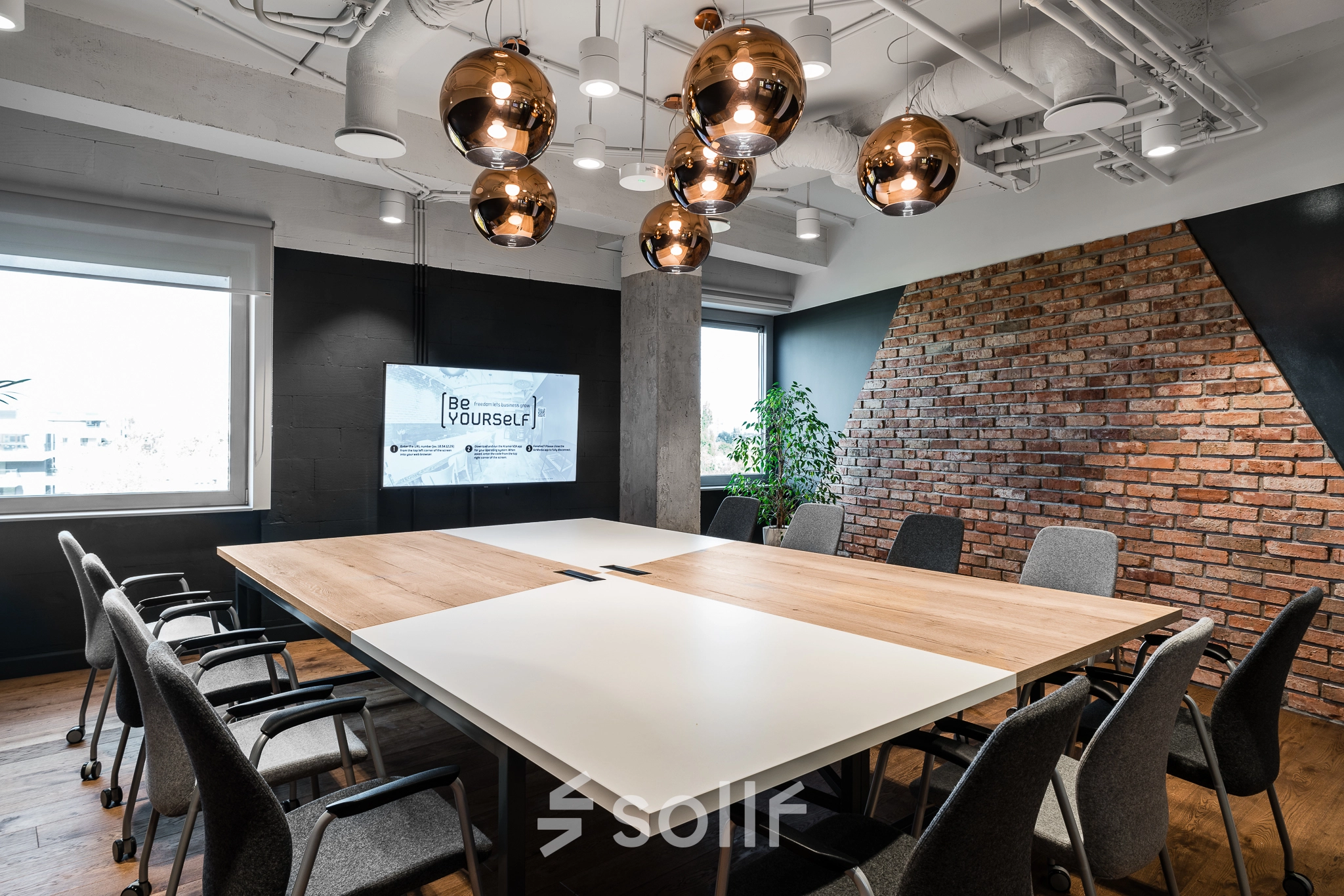 Modern conference room at Konstruktorska 11, Warsaw Mokotow, available for office space rental, featuring a large table, chairs, and stylish lighting.