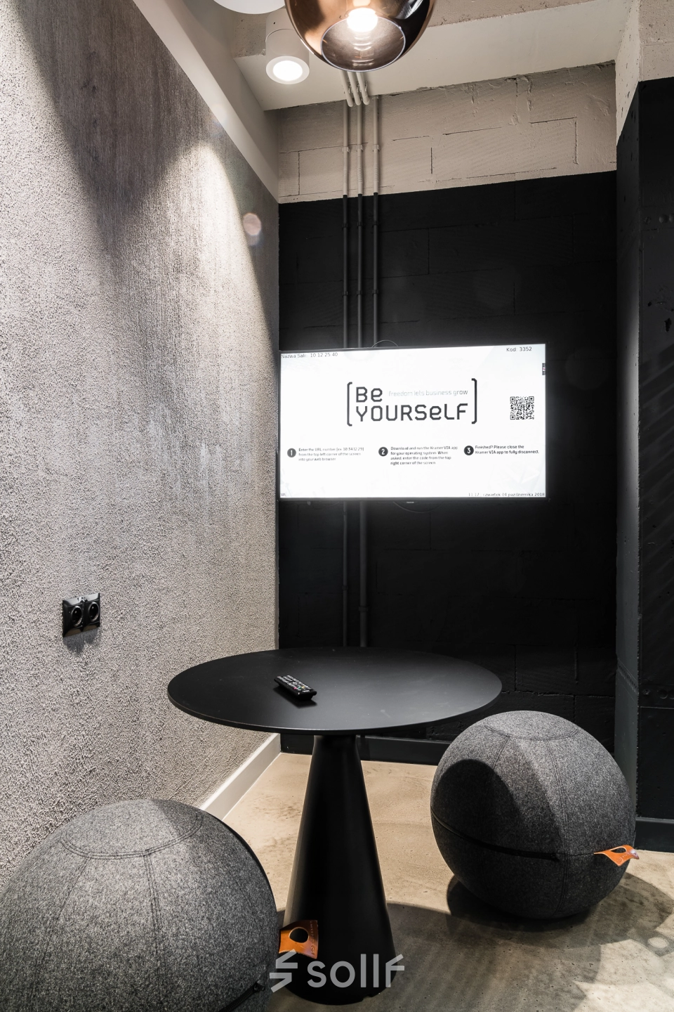 Modern office space to rent at Konstruktorska 11, Warsaw Mokotow featuring a stylish small workspace with a round table and seating.
