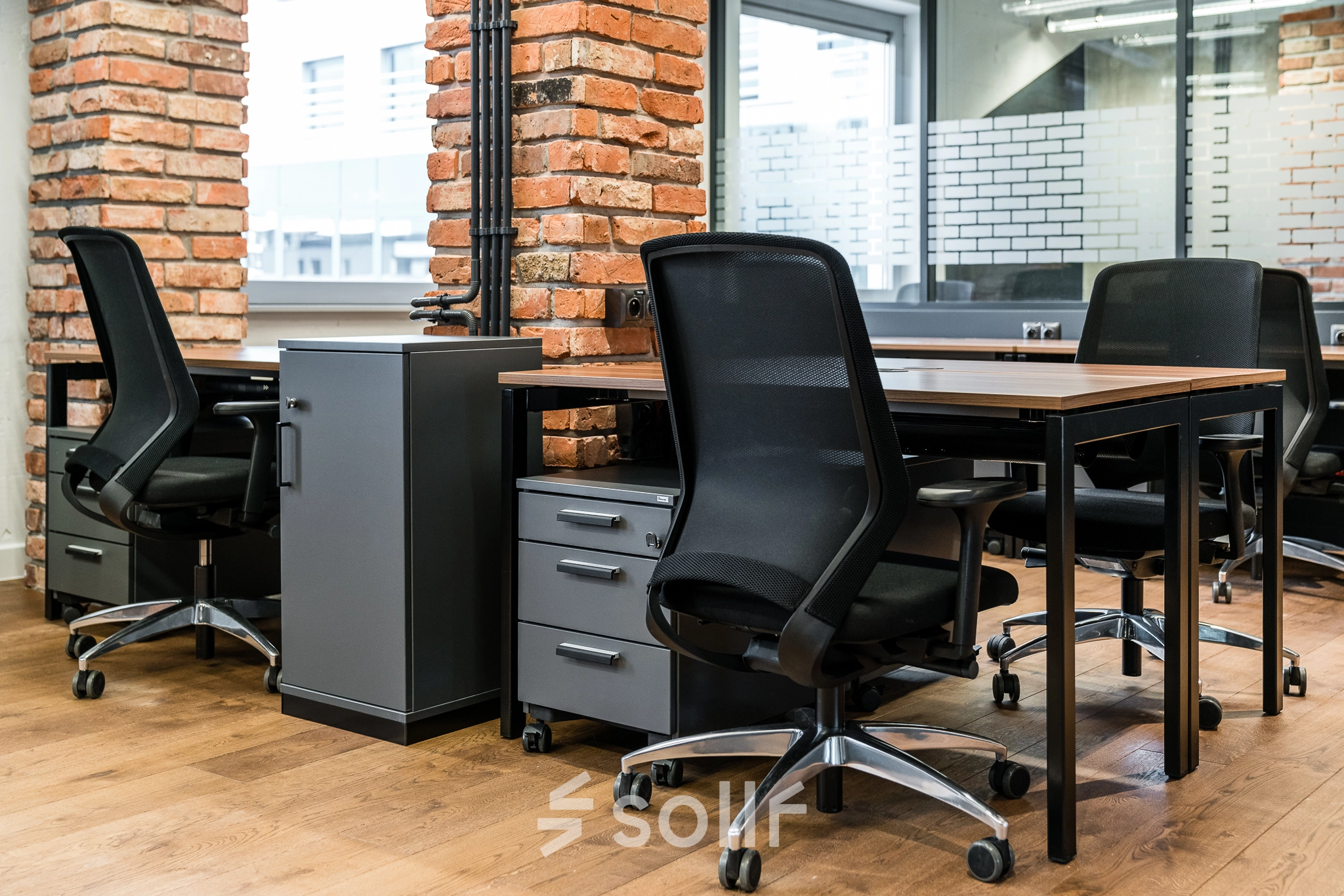 Modern office space with brick accents and sleek furniture at Konstruktorska 11, Warsaw Mokotow. Ideal for efficient workspace rental.