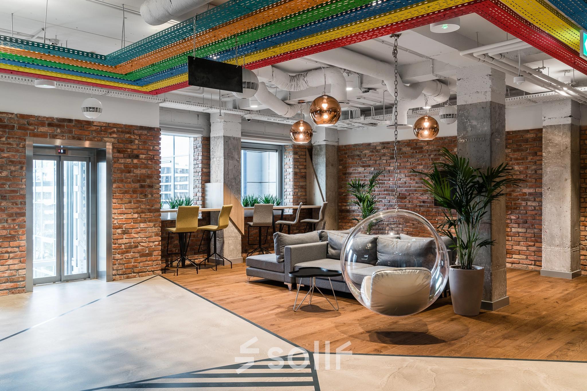 Modern office space for rent in Warsaw Mokotow, featuring stylish decor, cozy seating areas, and plants enhancing a welcoming atmosphere.