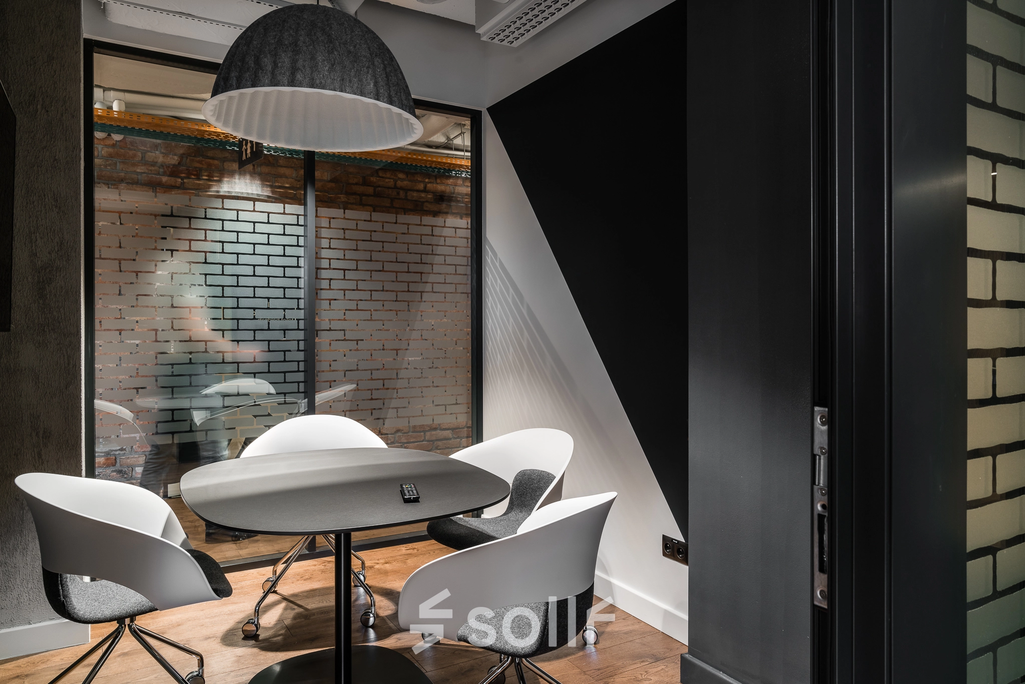 Modern office space rental at Konstruktorska 11, Warsaw Mokotow, featuring a small meeting area with stylish chairs and a round table.